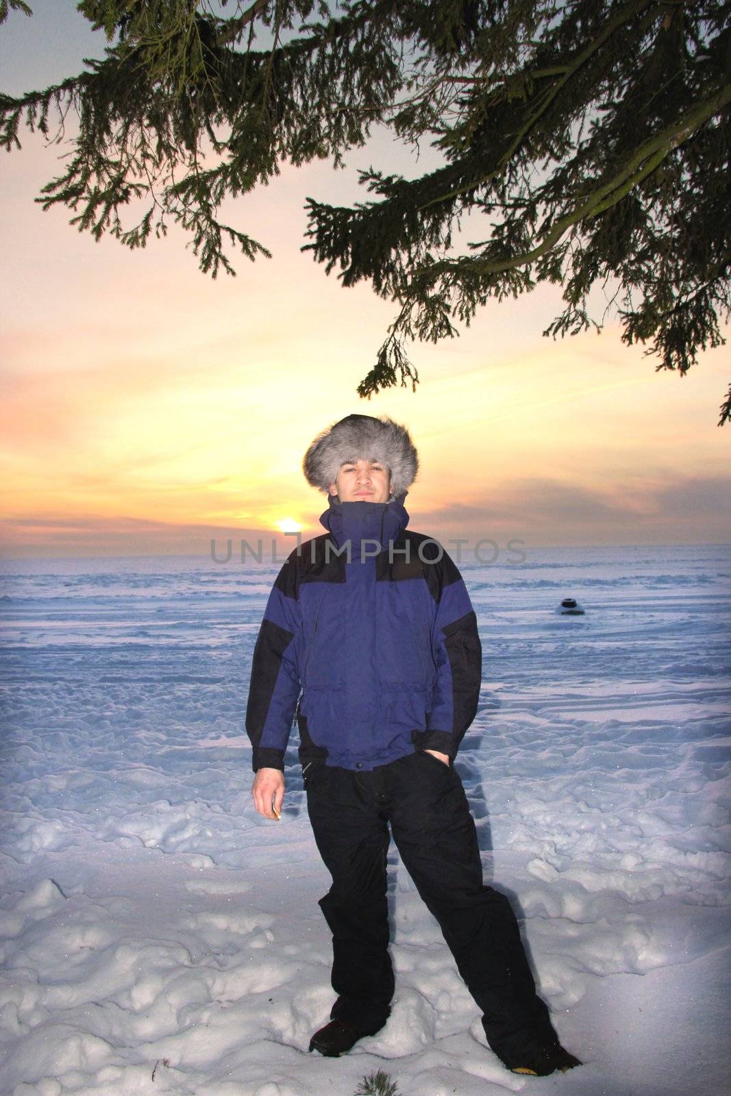 man  in a fur cap in winter sunset by Metanna