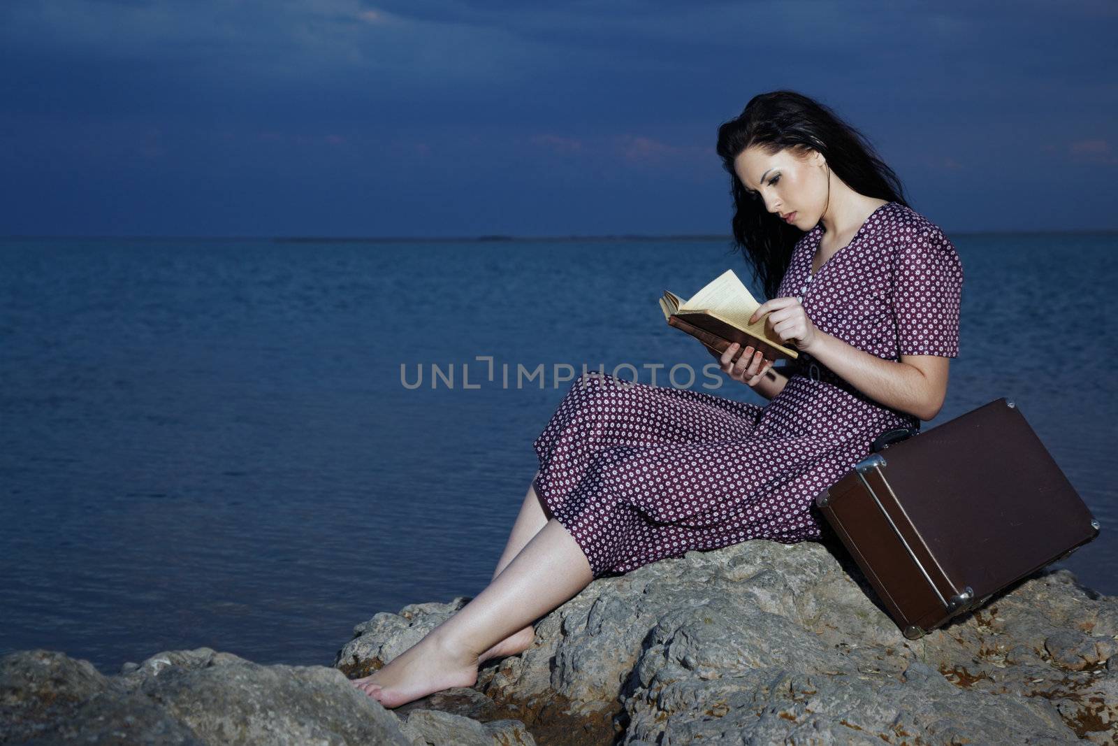 Lady sitting at the beach and reading book