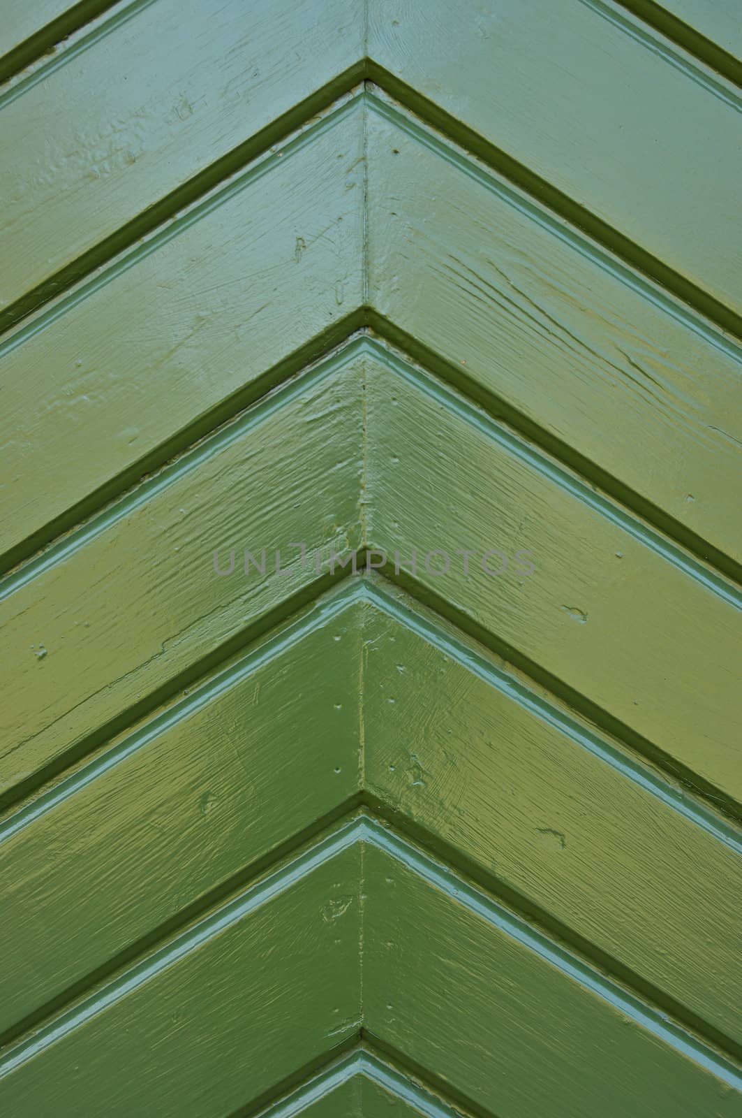 A wooden pattern on a door, painted green.