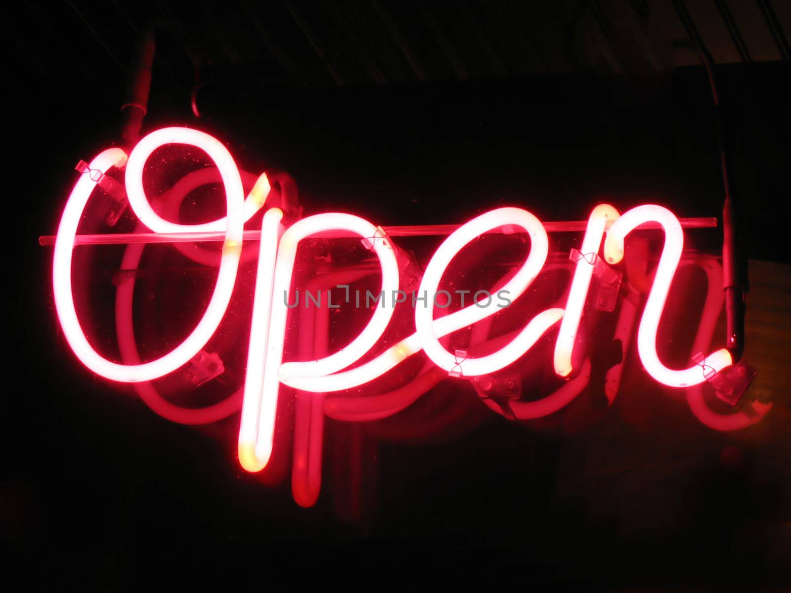 A neon "open" sign glowing red in the window of a restaurant.