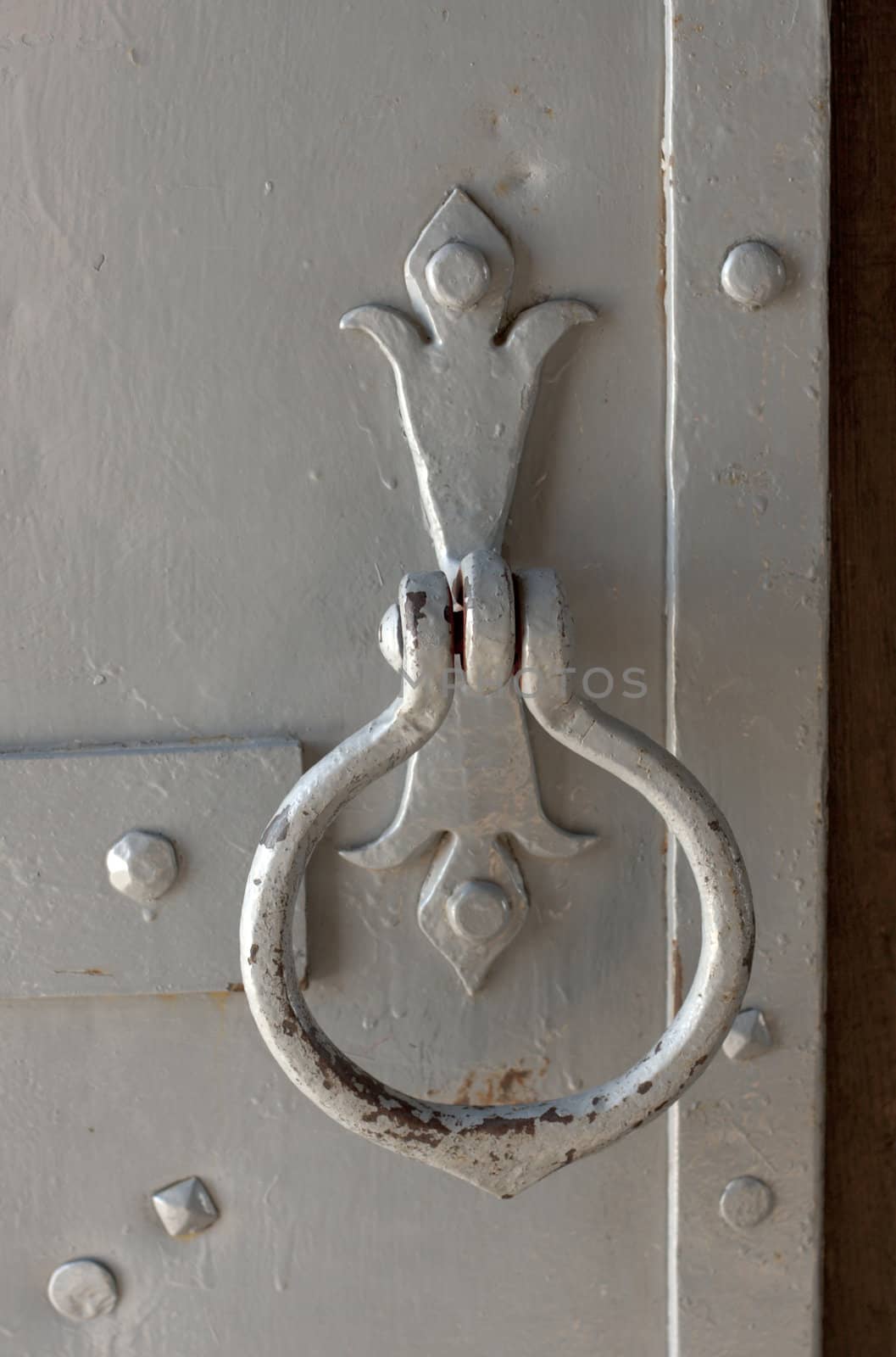 old metal handle to the door of gray