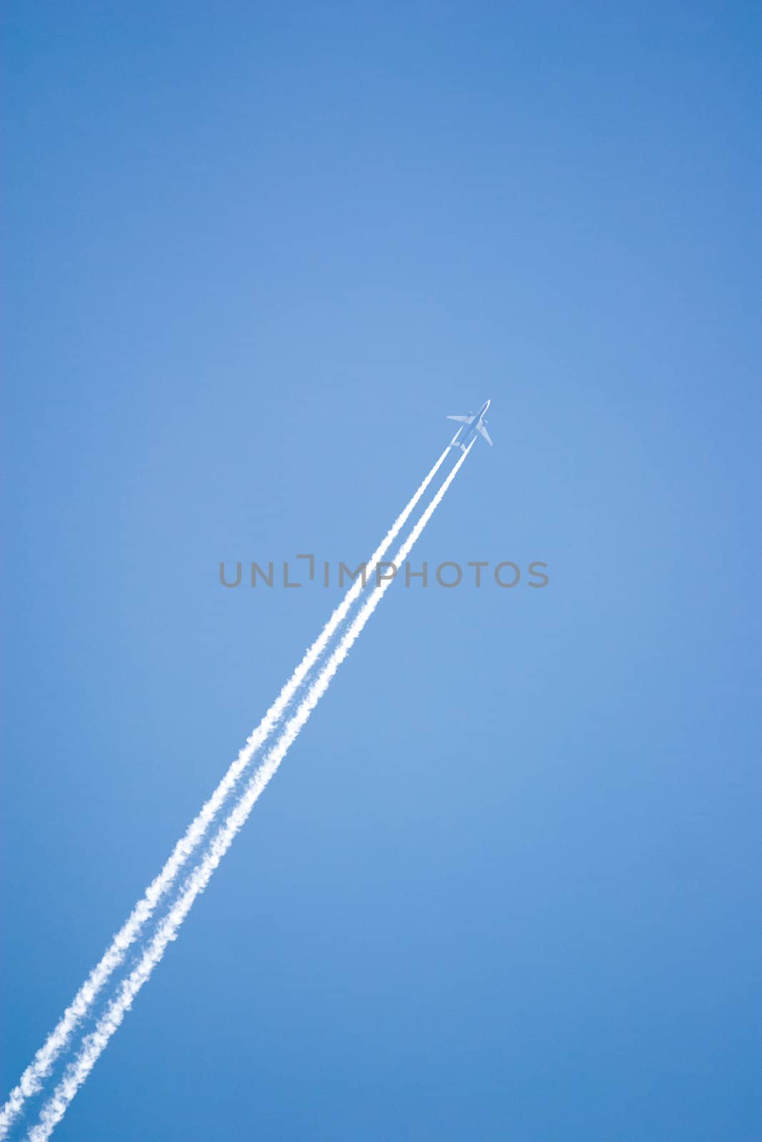 White airplane trace on blue sky

