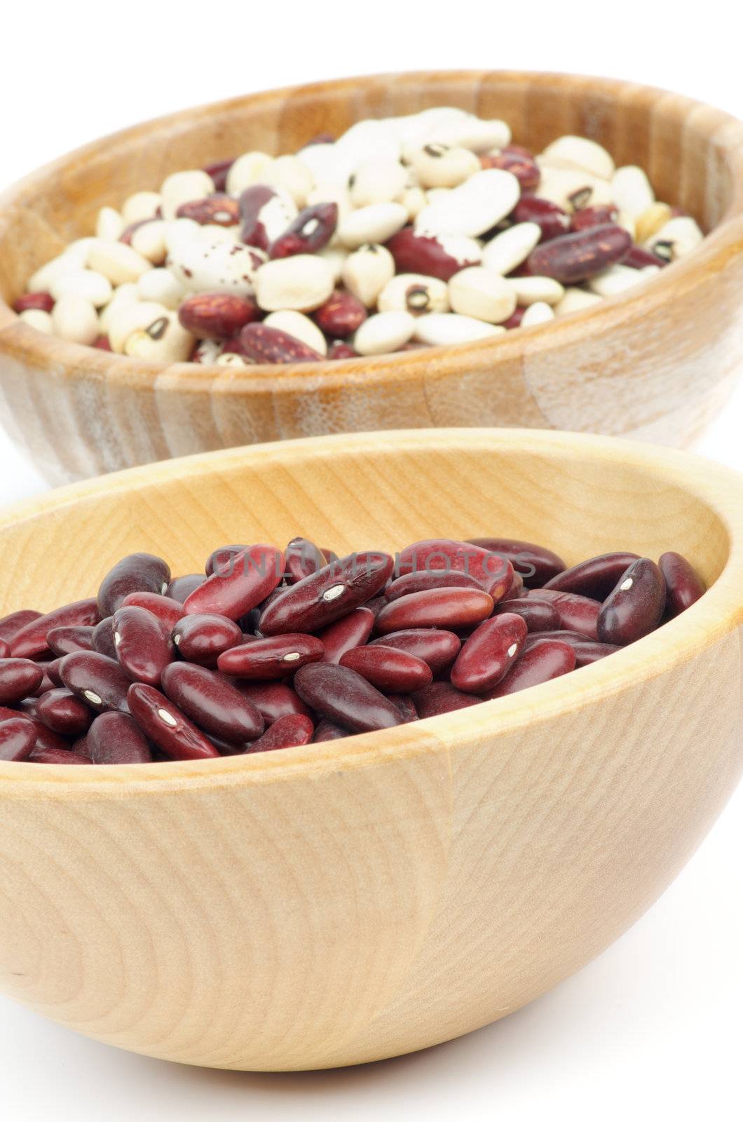 Two Wooden Bowls with Red, White and Variegated Bean closeup on white background