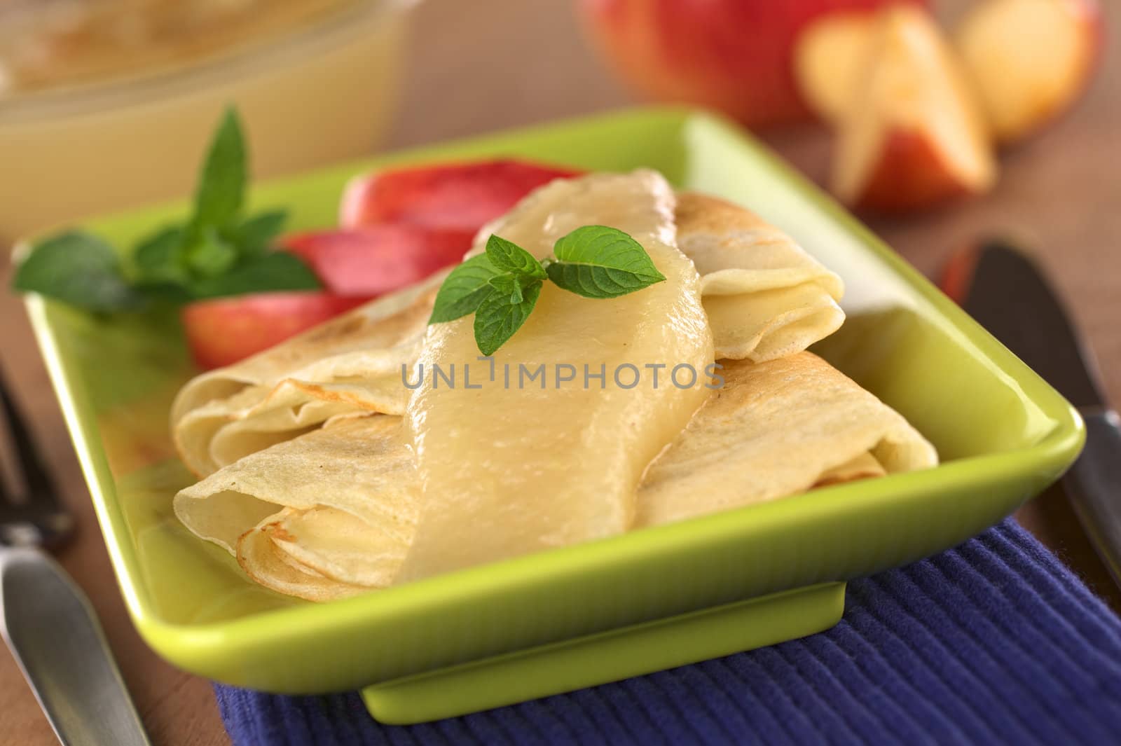 Crepes with apple sauce (Selective Focus, Focus on the mint leaf)