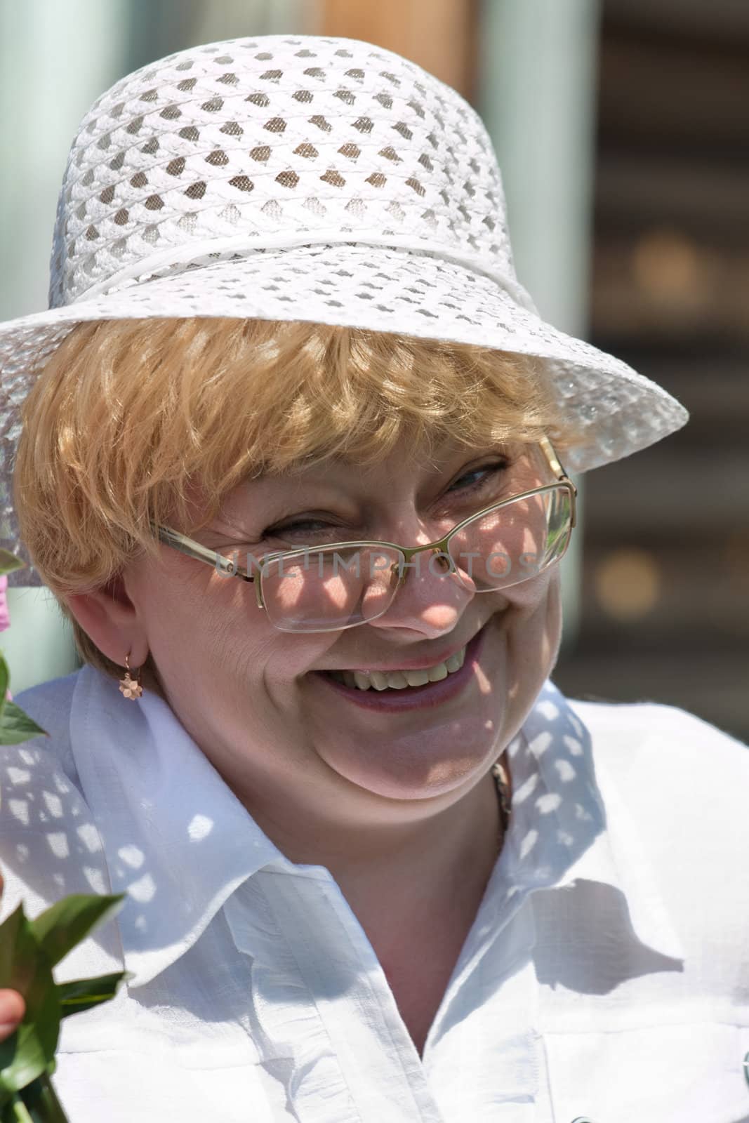 The smiling woman in a hat and glasses

