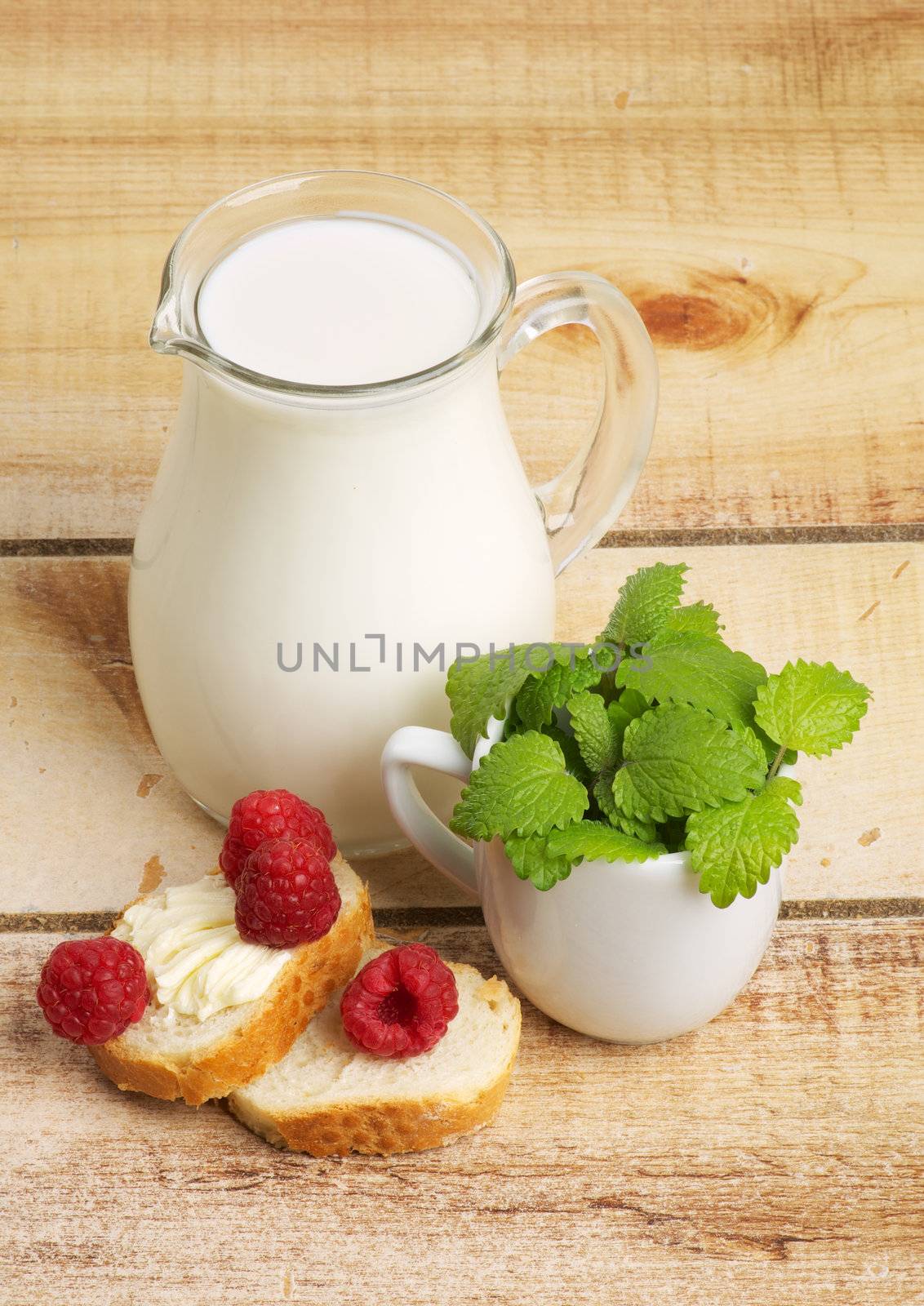 Healthy Breakfast with Jug of Milk, Raspberries, Mint Leafs and Toasts on Wooden background