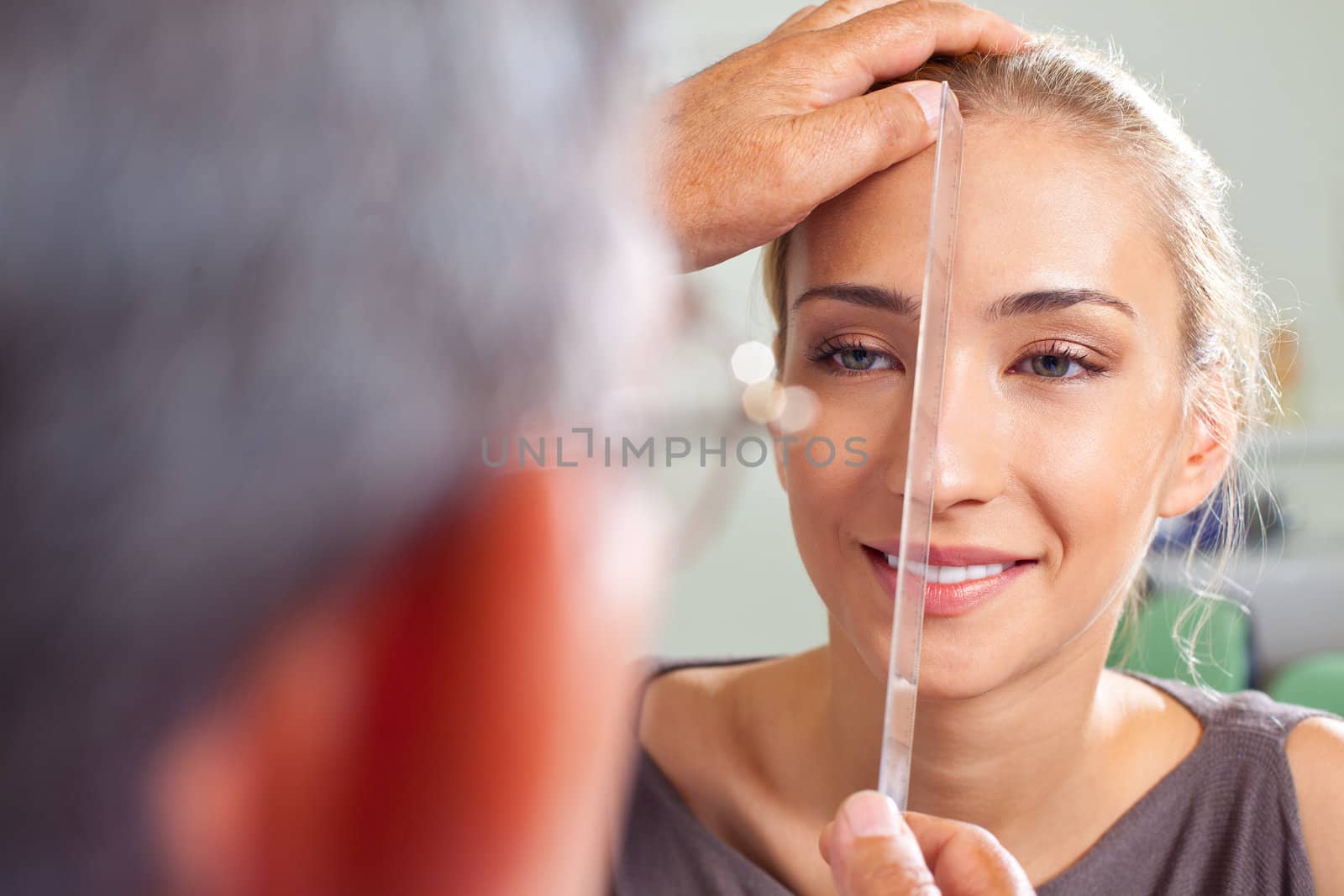 Close-up of female face being measured by plastic surgery doctor