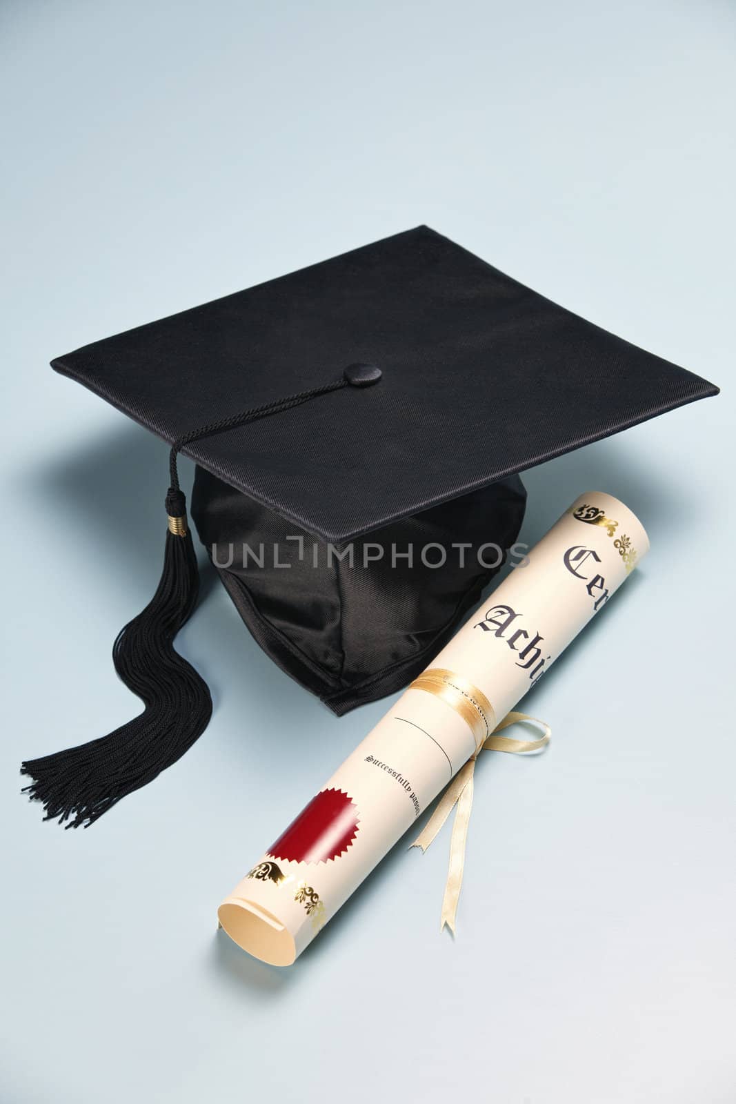 mortar board and the certificate on the plain background