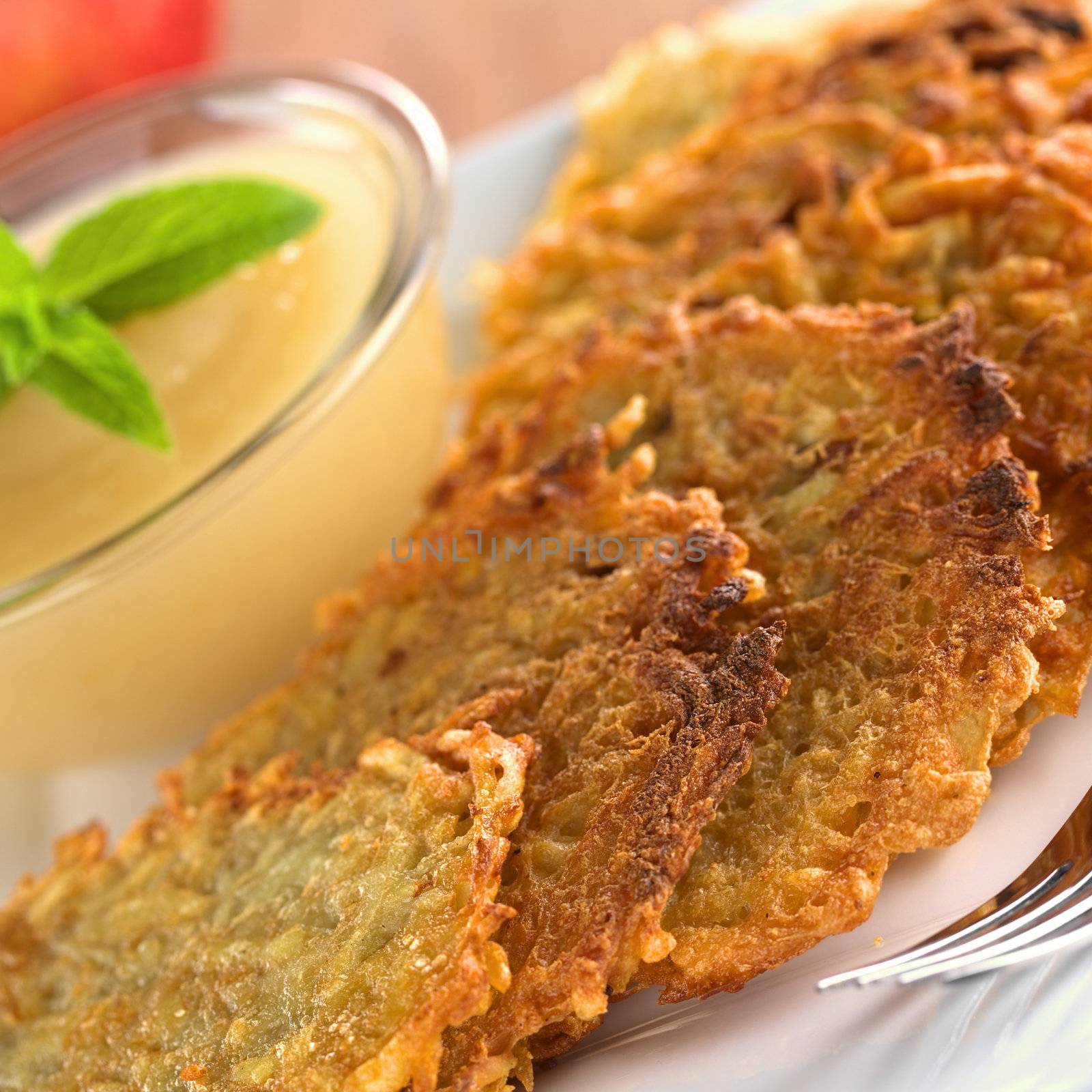 Potato fritters with apple sauce (Selective Focus, Focus one third into the first fritters)