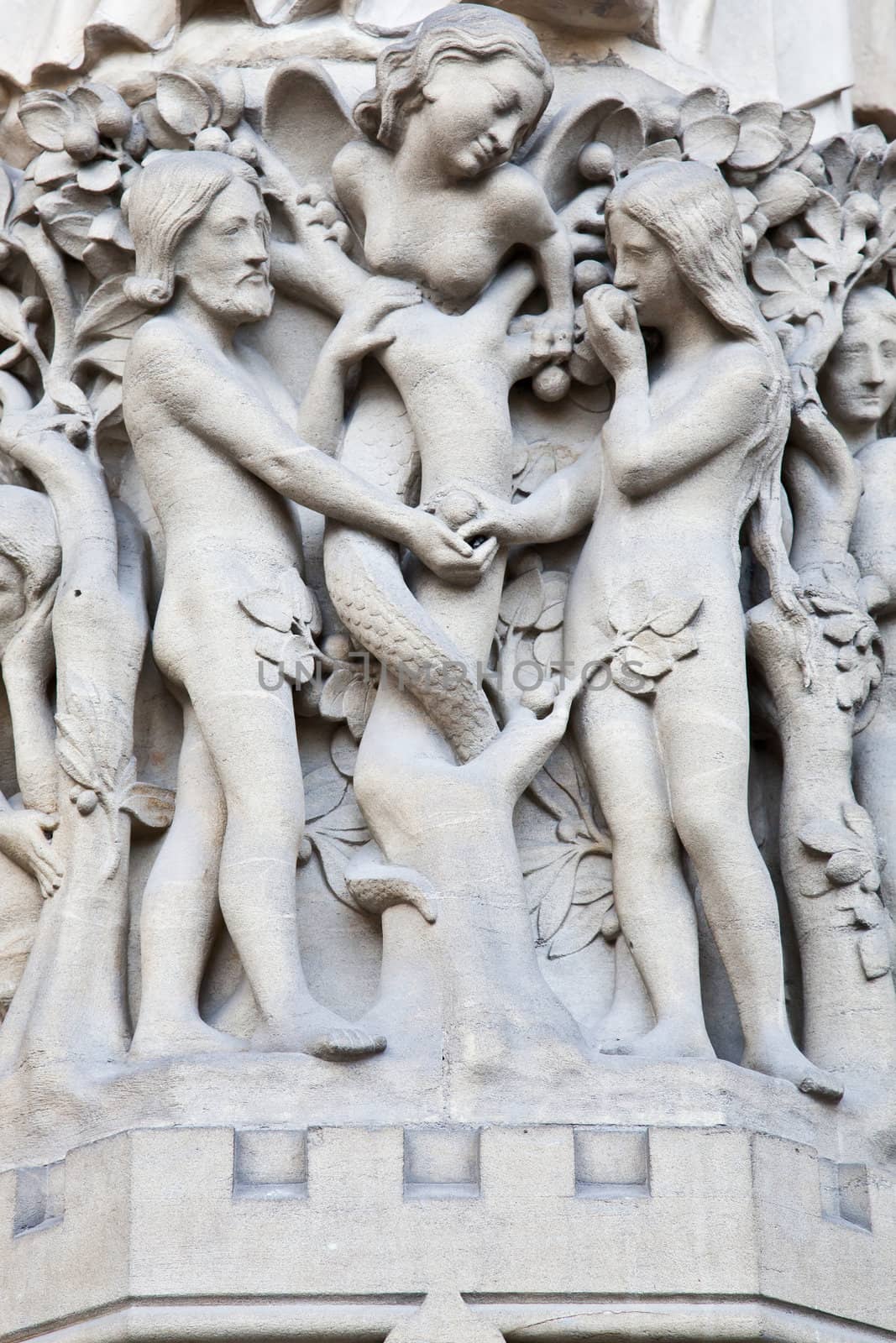 Detail on Notre Dame de Paris Cathedral fachade: Adame, Eve and the forbidden apple