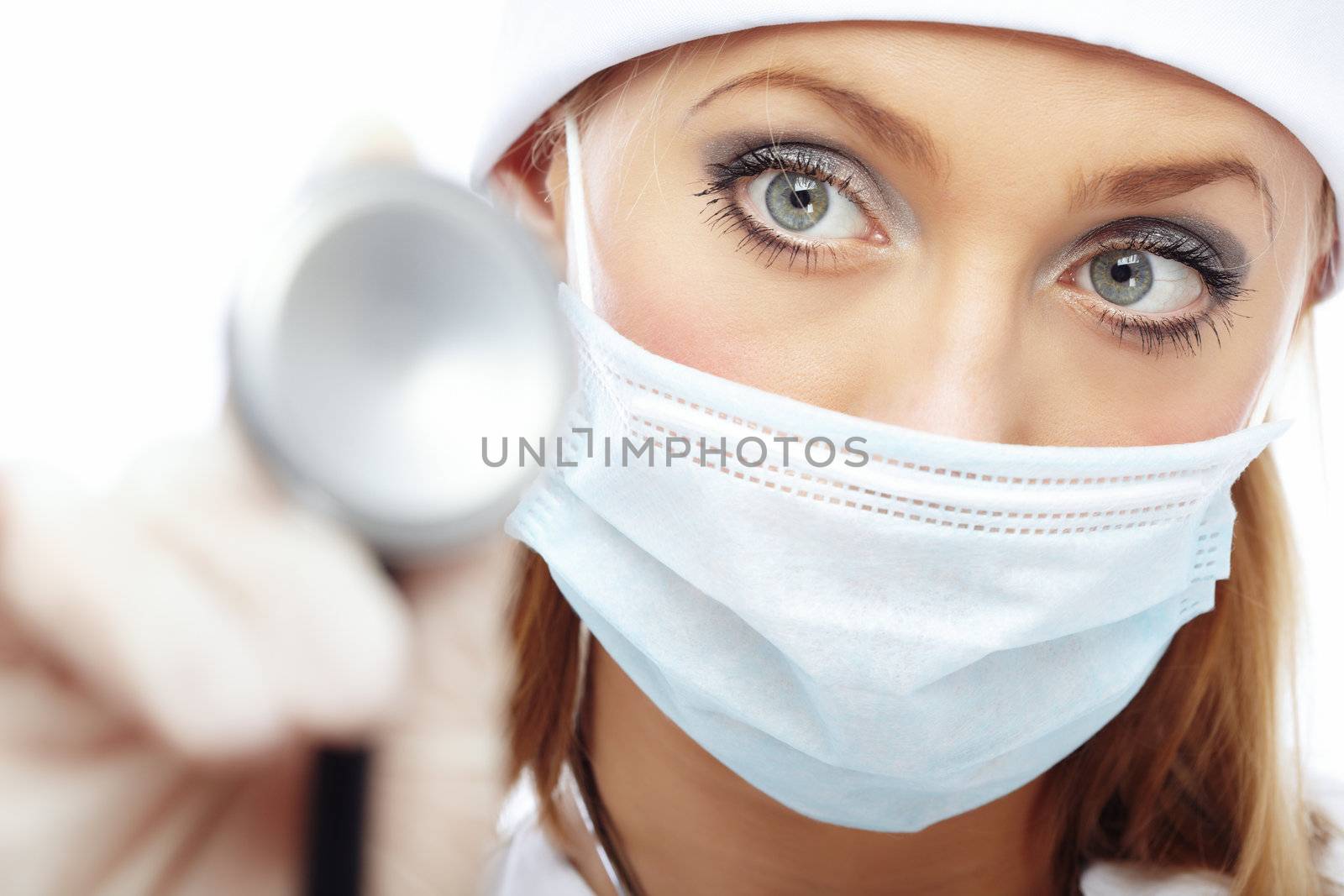 Close-up portrait of the female doctor in protective mask holding stethoscope