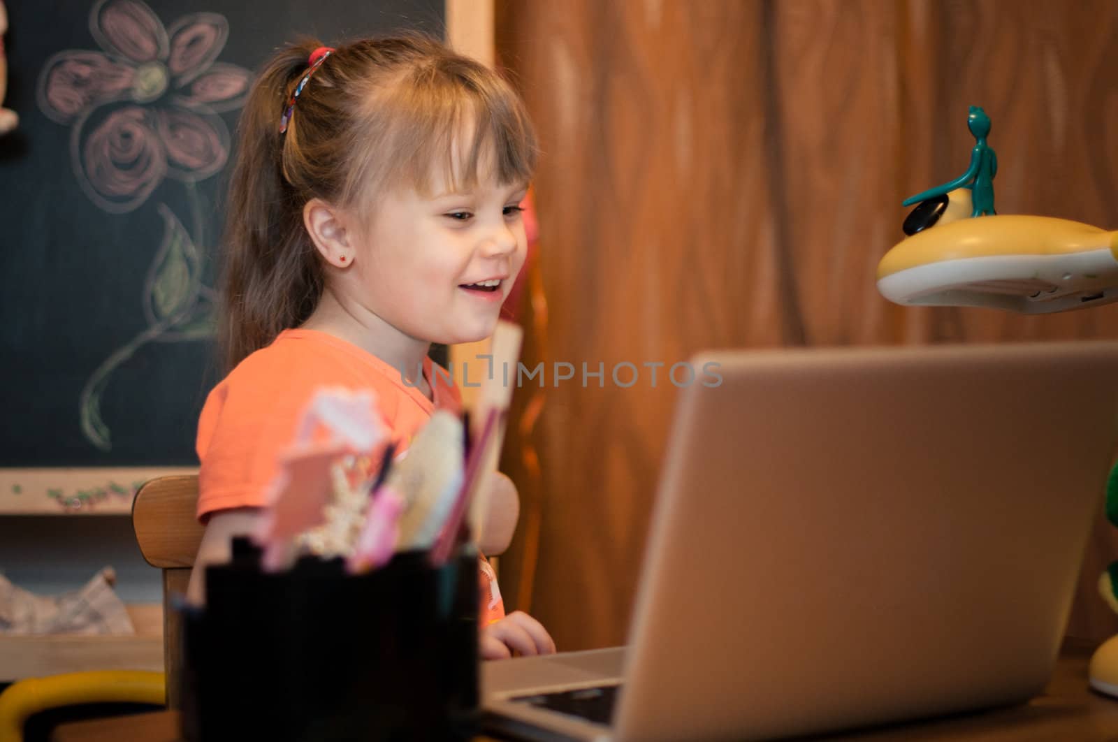 Young girl laughing with laptop in her small room