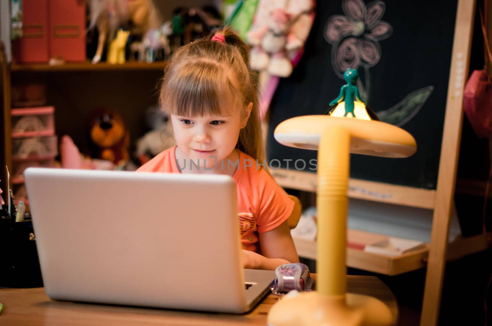 In small room young girl looking in her laptop and smiling