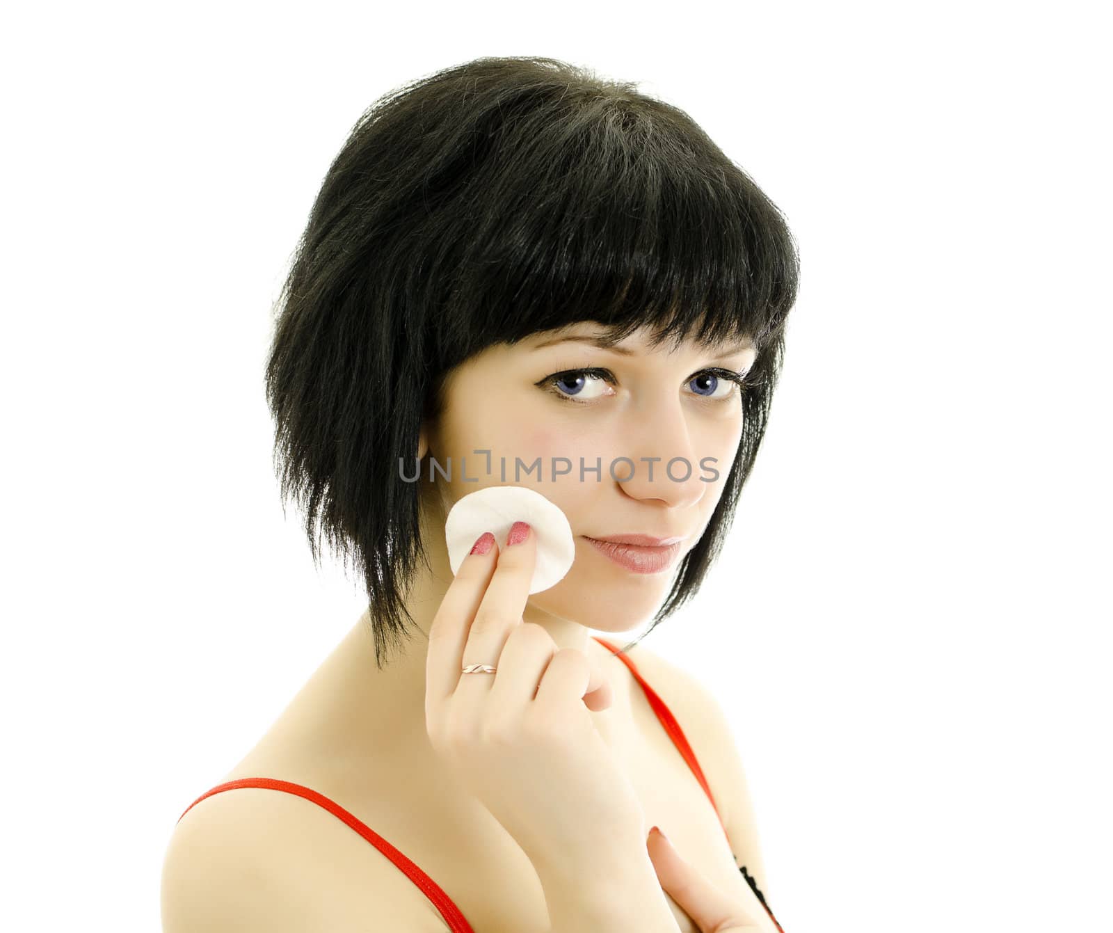 Close-up portrait of woman with cotton swab cleaning her face. Isolated on white.
