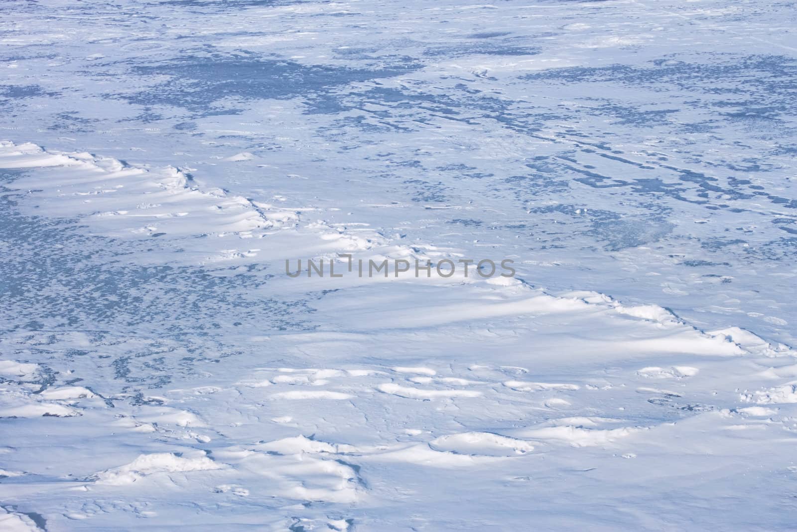 Snow hummocks on the surface of frozen reservoir