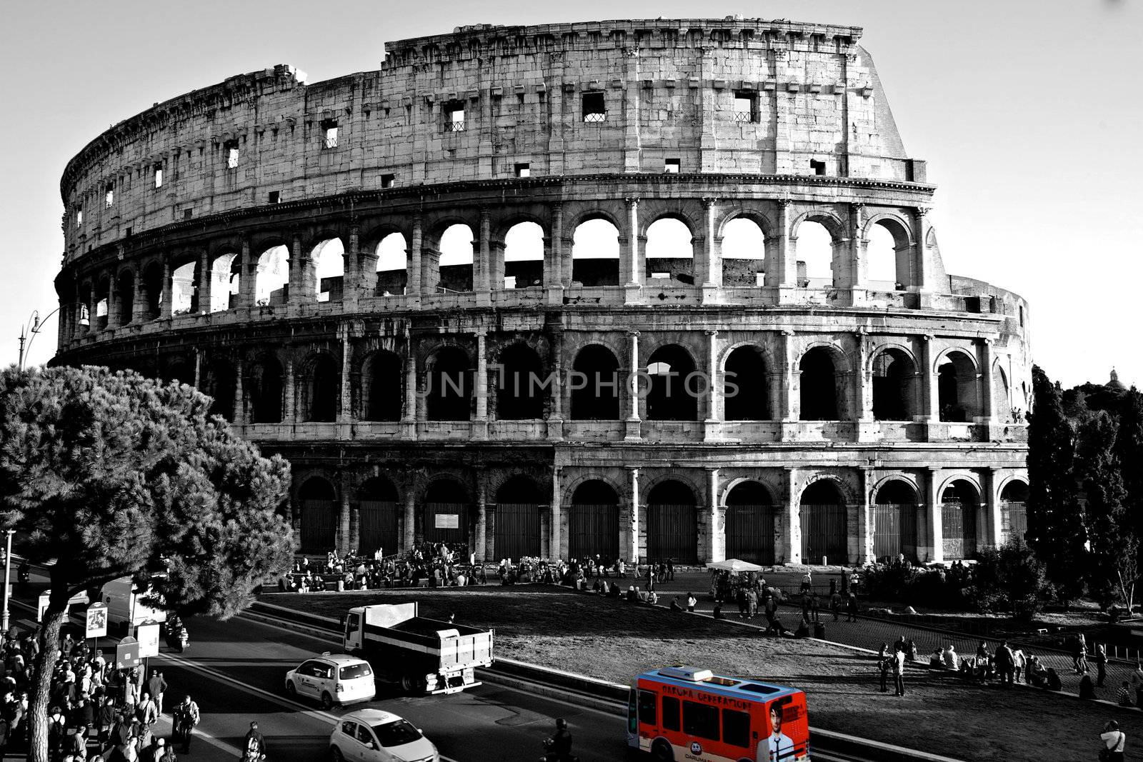 Colosseum in black and white with a red bus