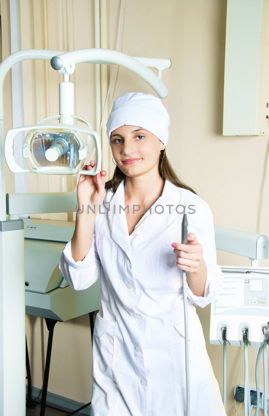 portrait of a young female dentist in the office with equipment