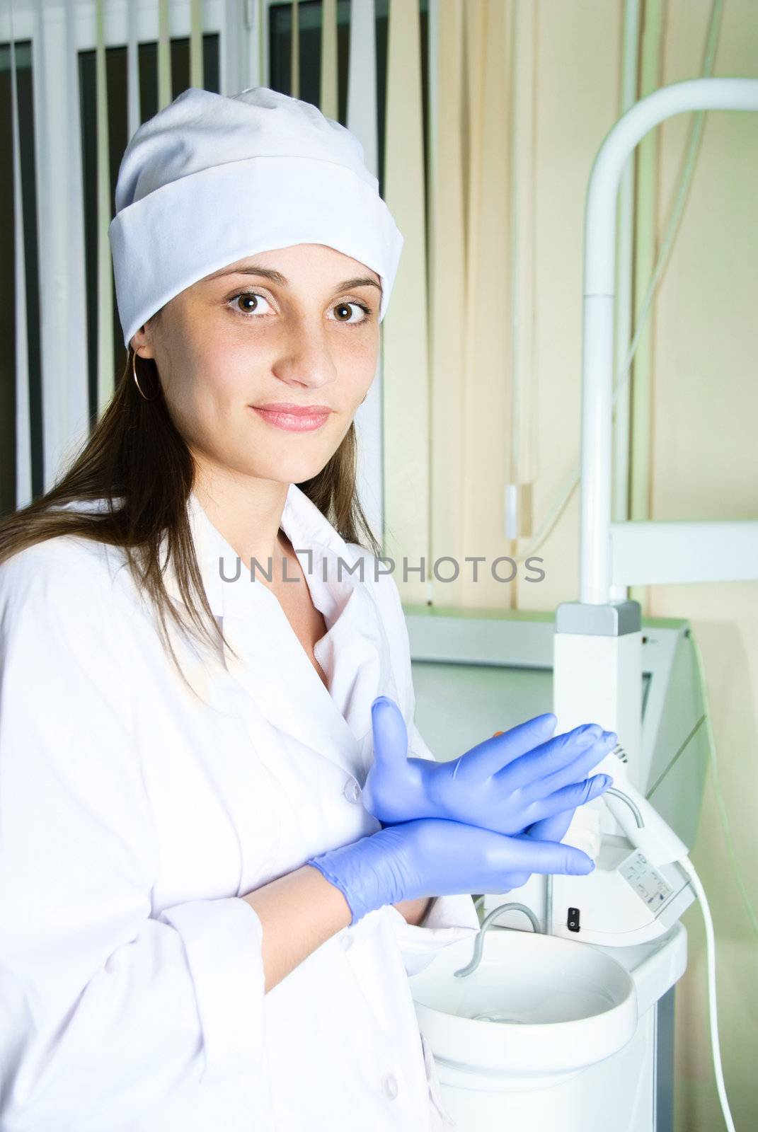 attractive young female dentist in her office at the end of the day