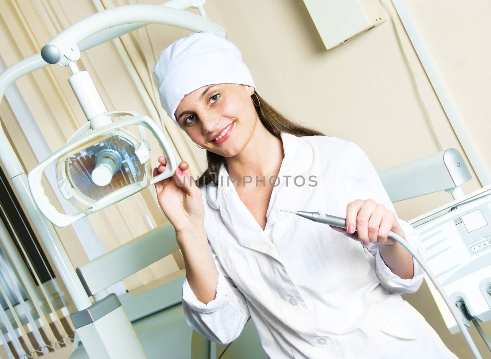 young woman-dentist in the office with equipment