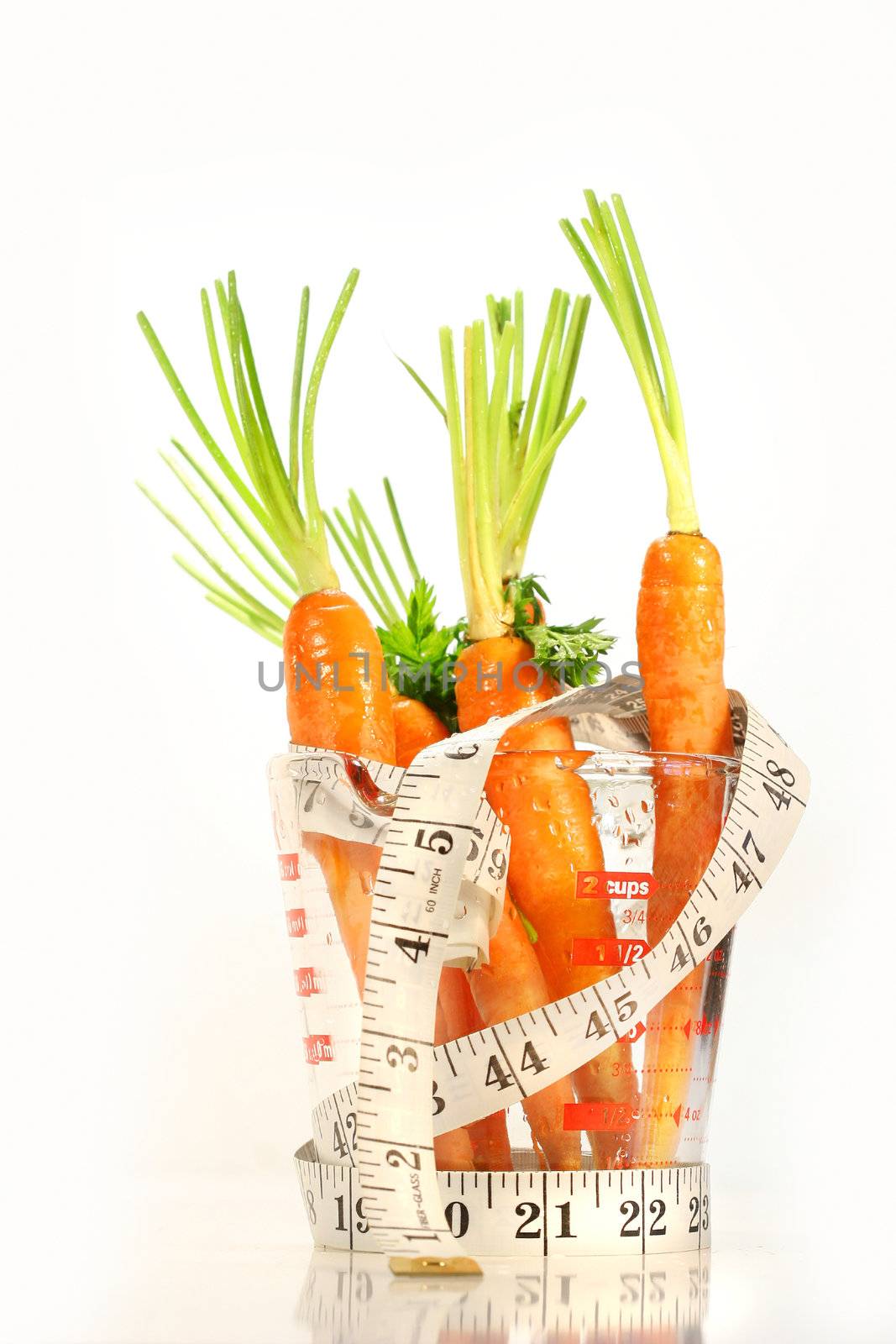 Carrots with water drops and a measuring tape wrapped around container