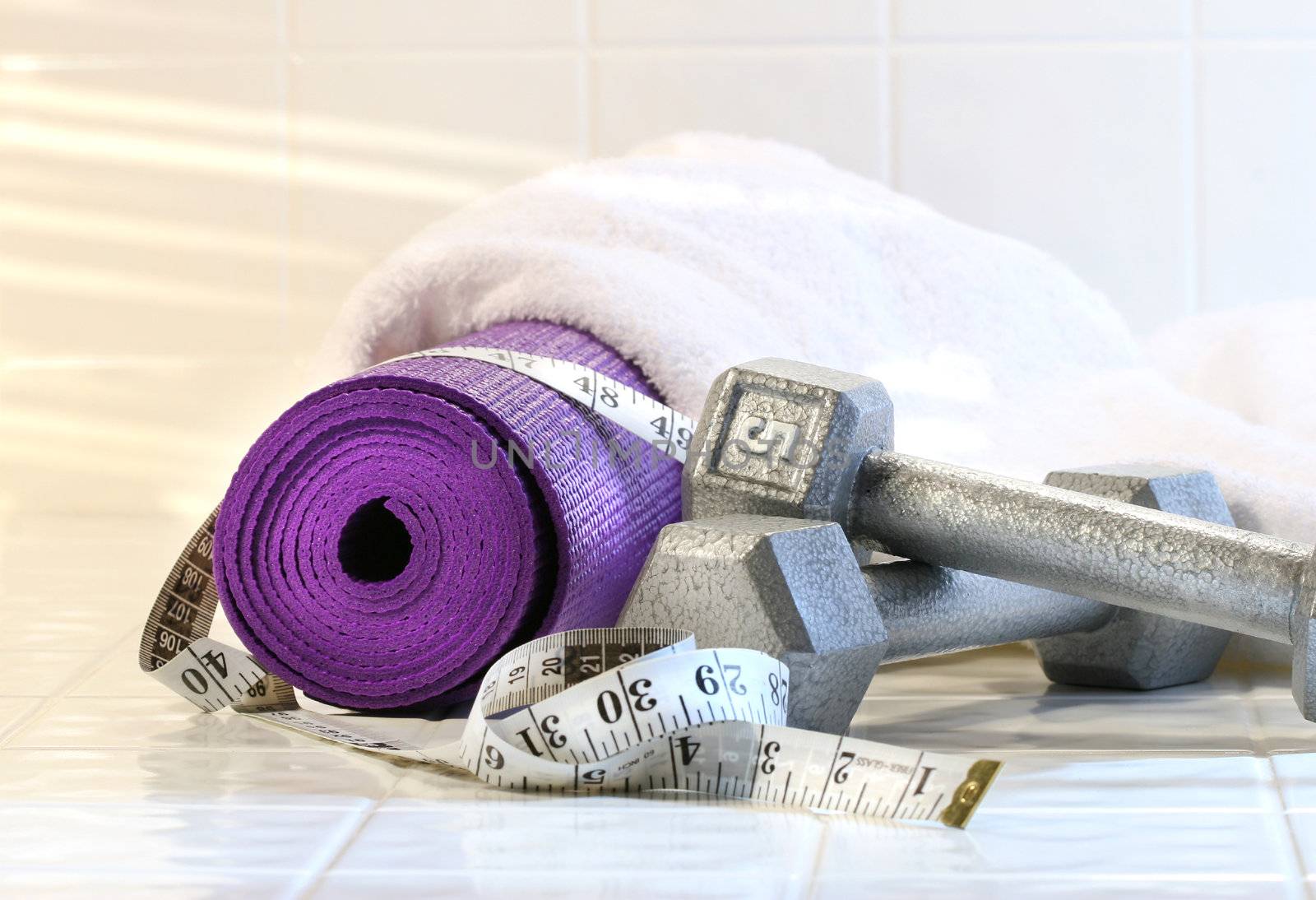 Excerise mat with weights on white tile floor