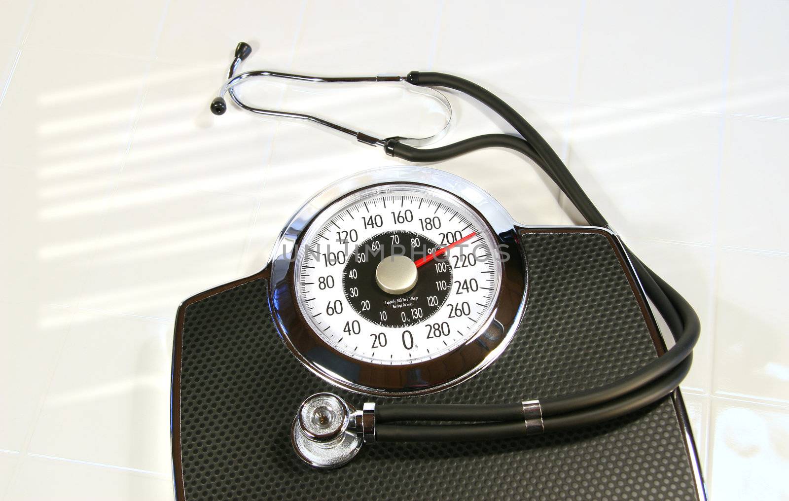Weight scale with sthetescope on white tile