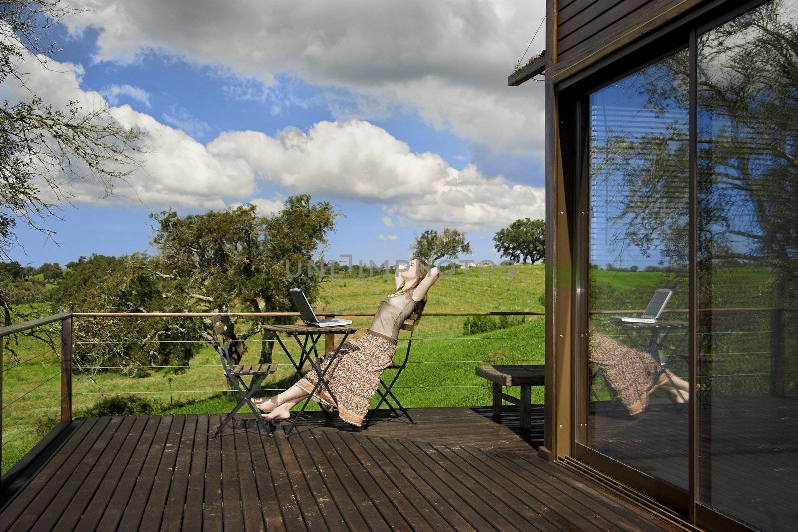 Woman enjoying a beautiful day with a laptop on her home-field