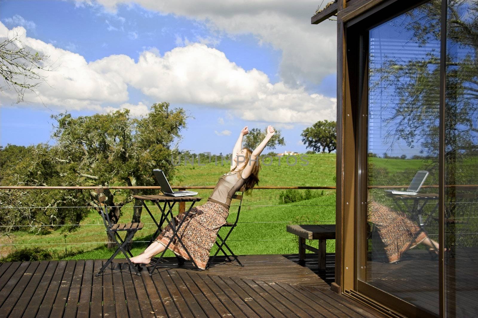 Woman enjoying a beautiful day with a laptop on her home-field