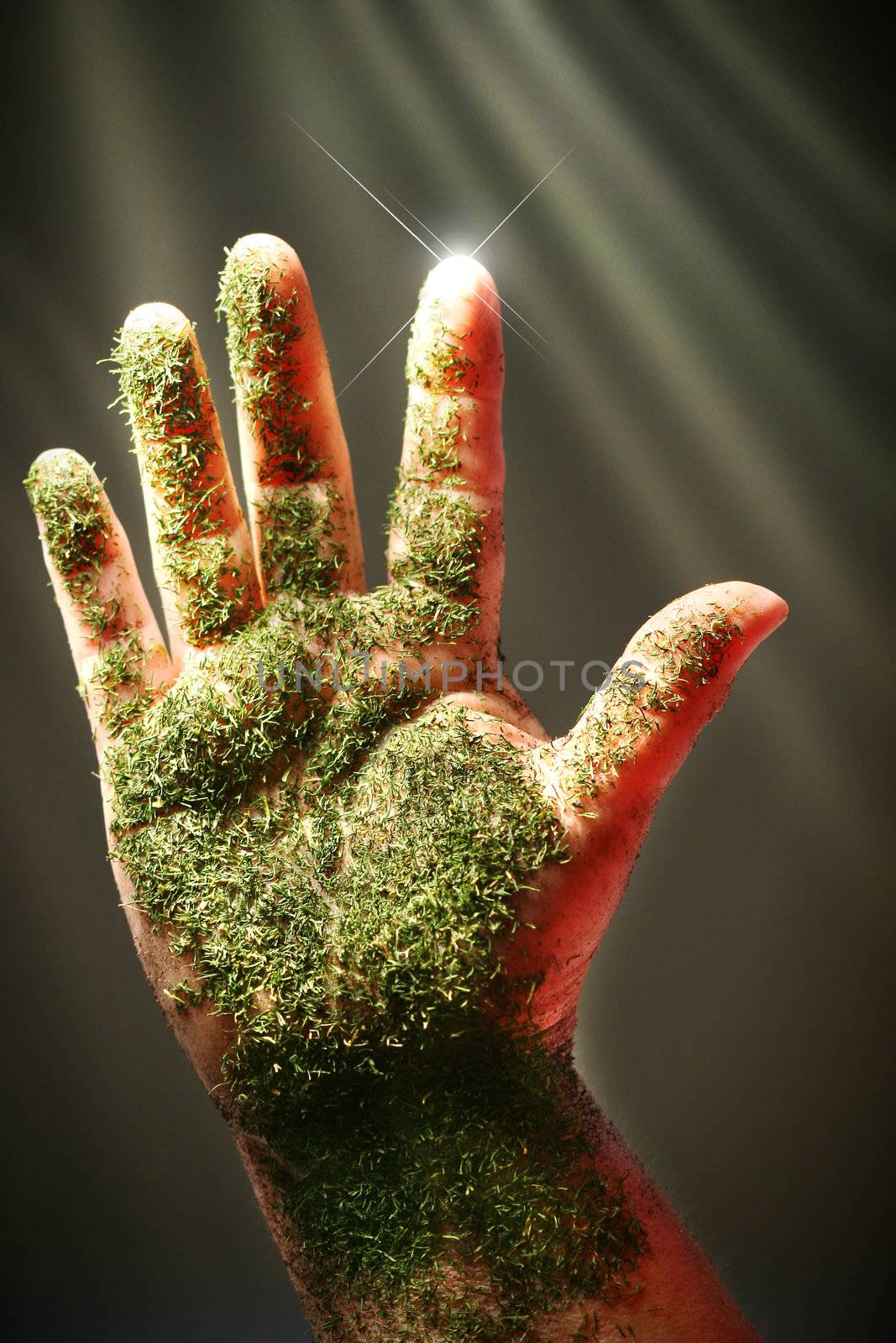 Open hand with green substance against dark background
