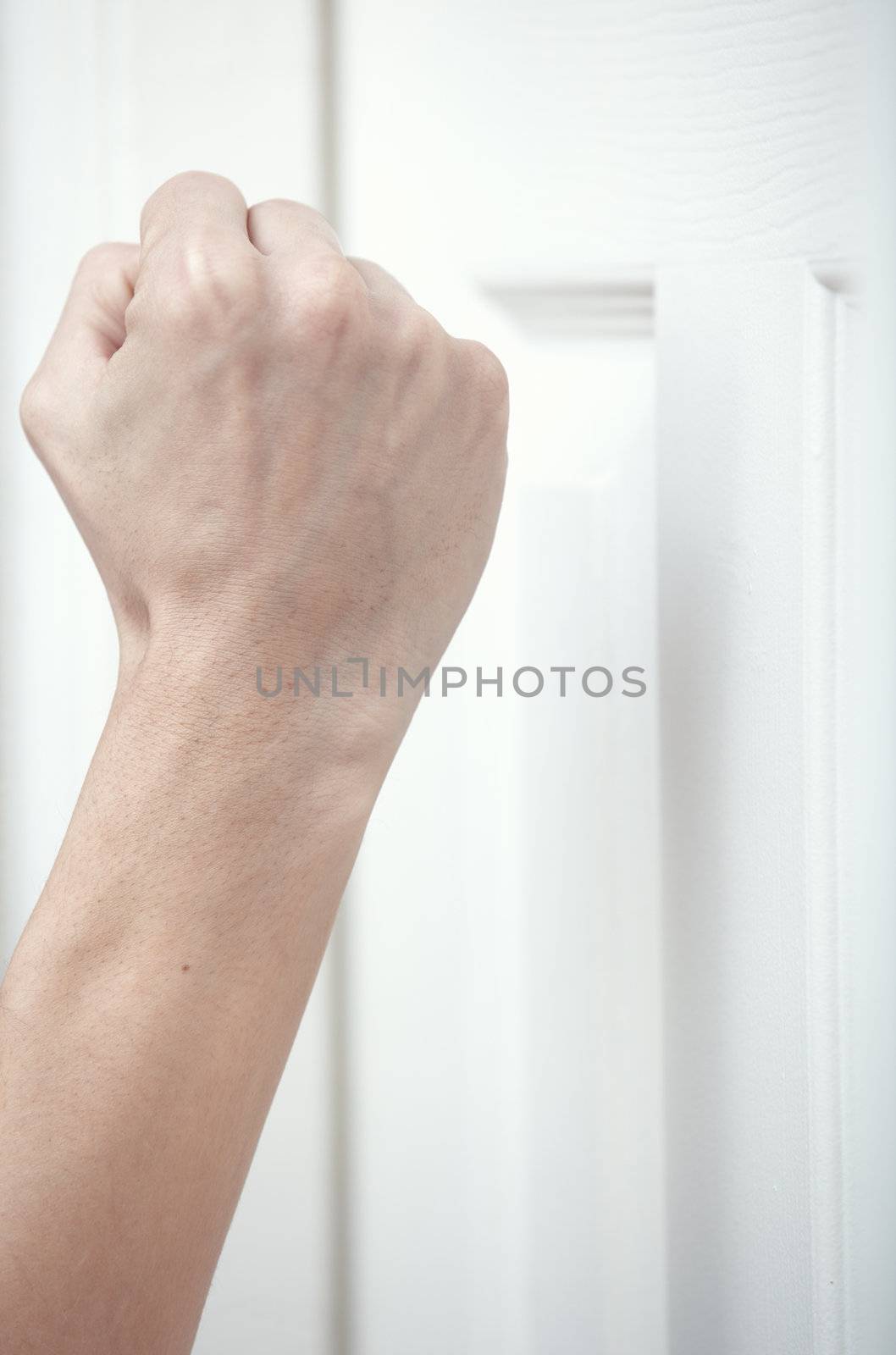 Human hand knocking at the wooden door