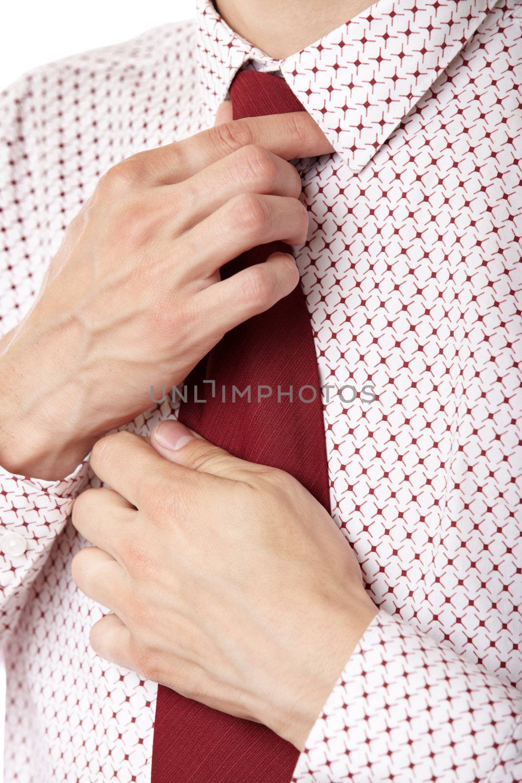 Close-up photo of the businessman knotting his red necktie