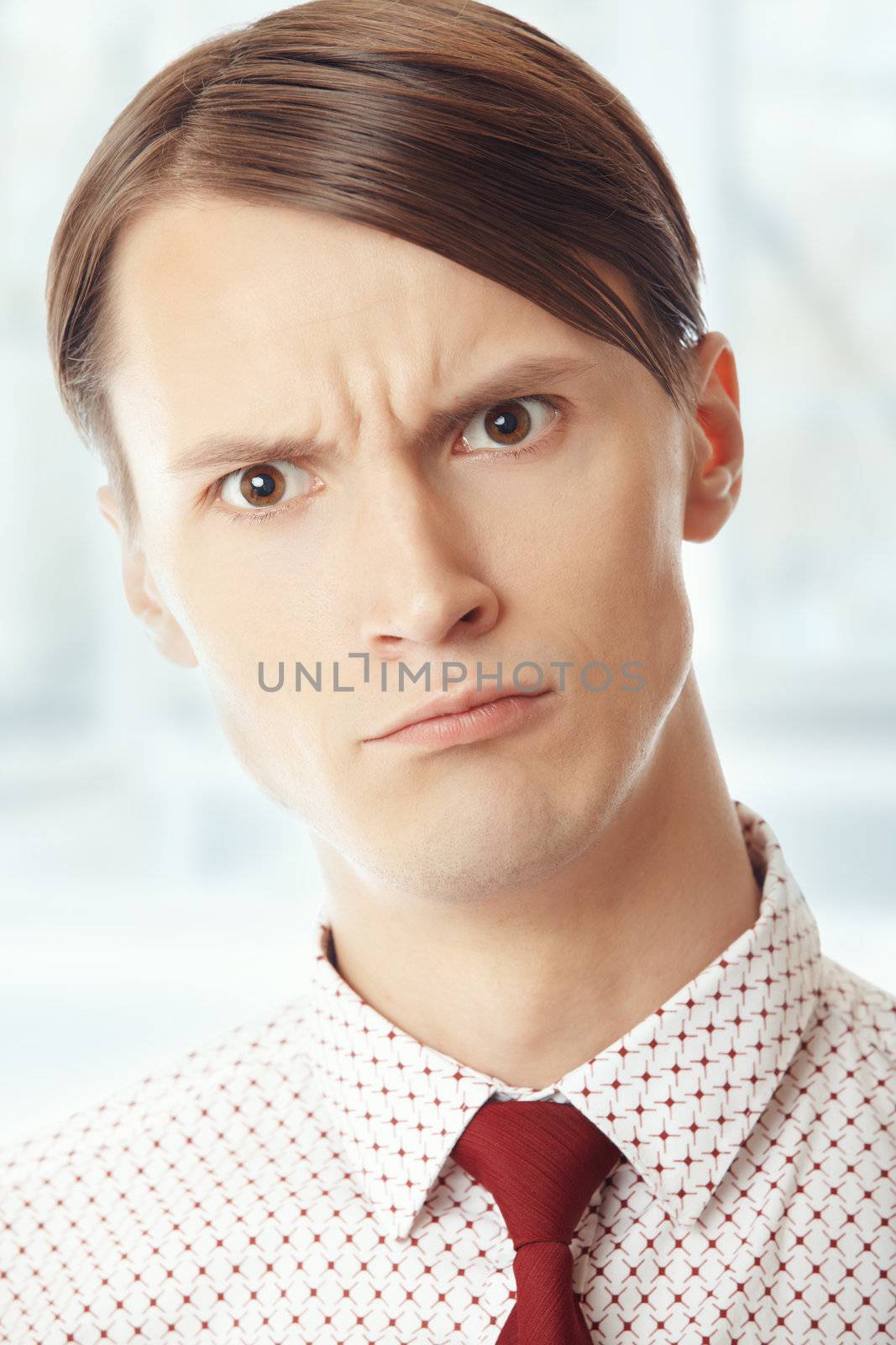 Displeased businessman at his office. Vertical portrait