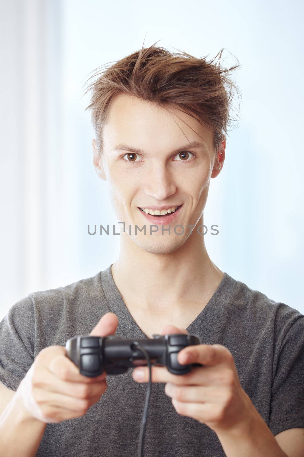 Man playing computer game and using joystick in his room