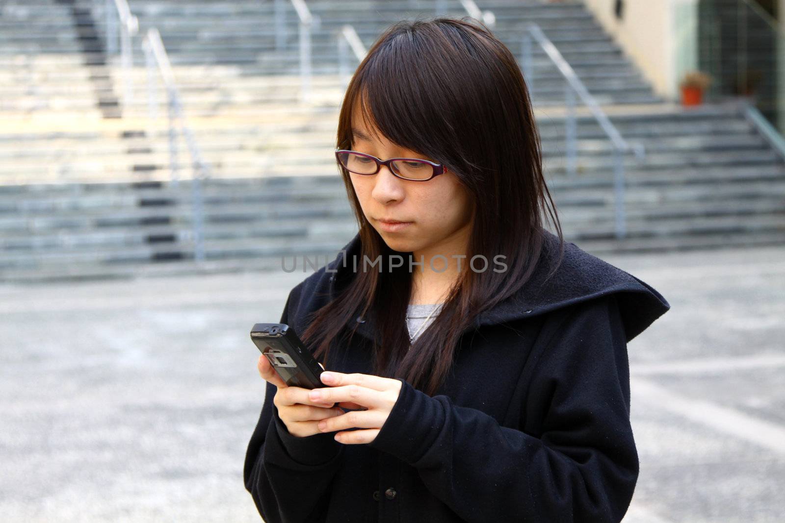 Asian woman texting message by phone