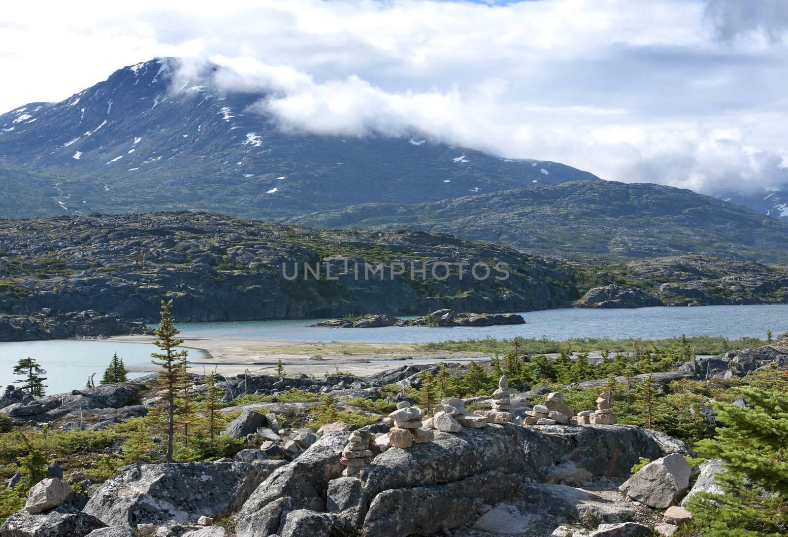 Piles of stones as Eskimo art form in front of glacier lake alon by Claudine