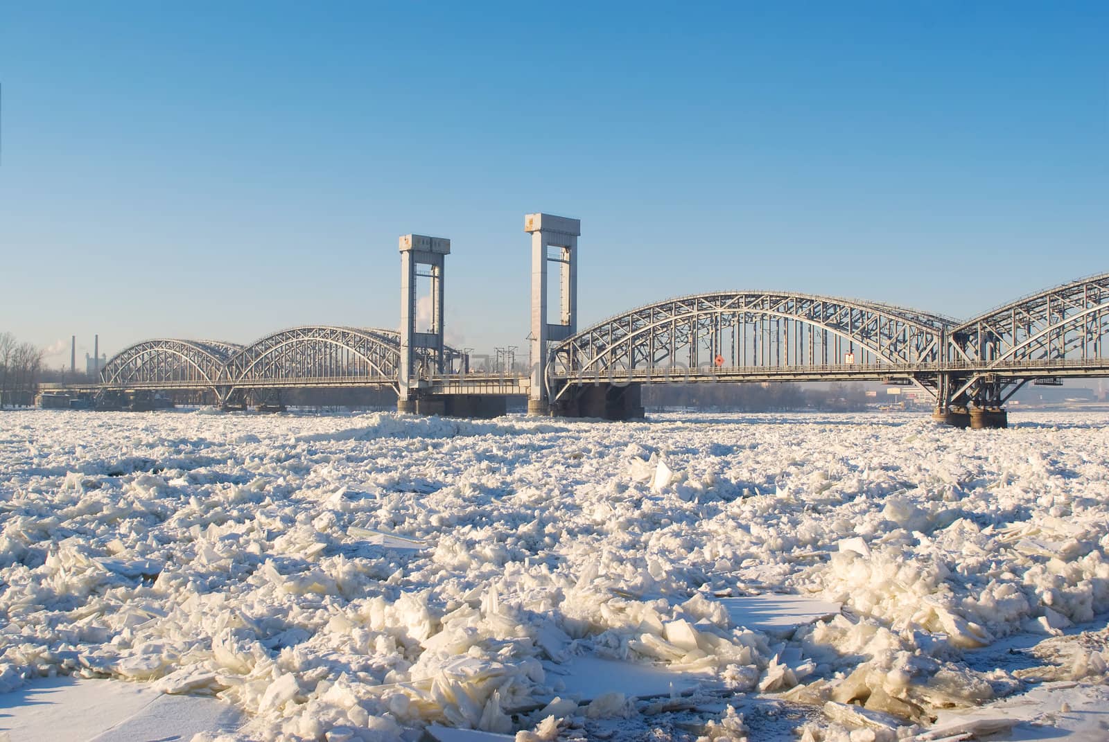 Bridge over the frozen river in sunny day