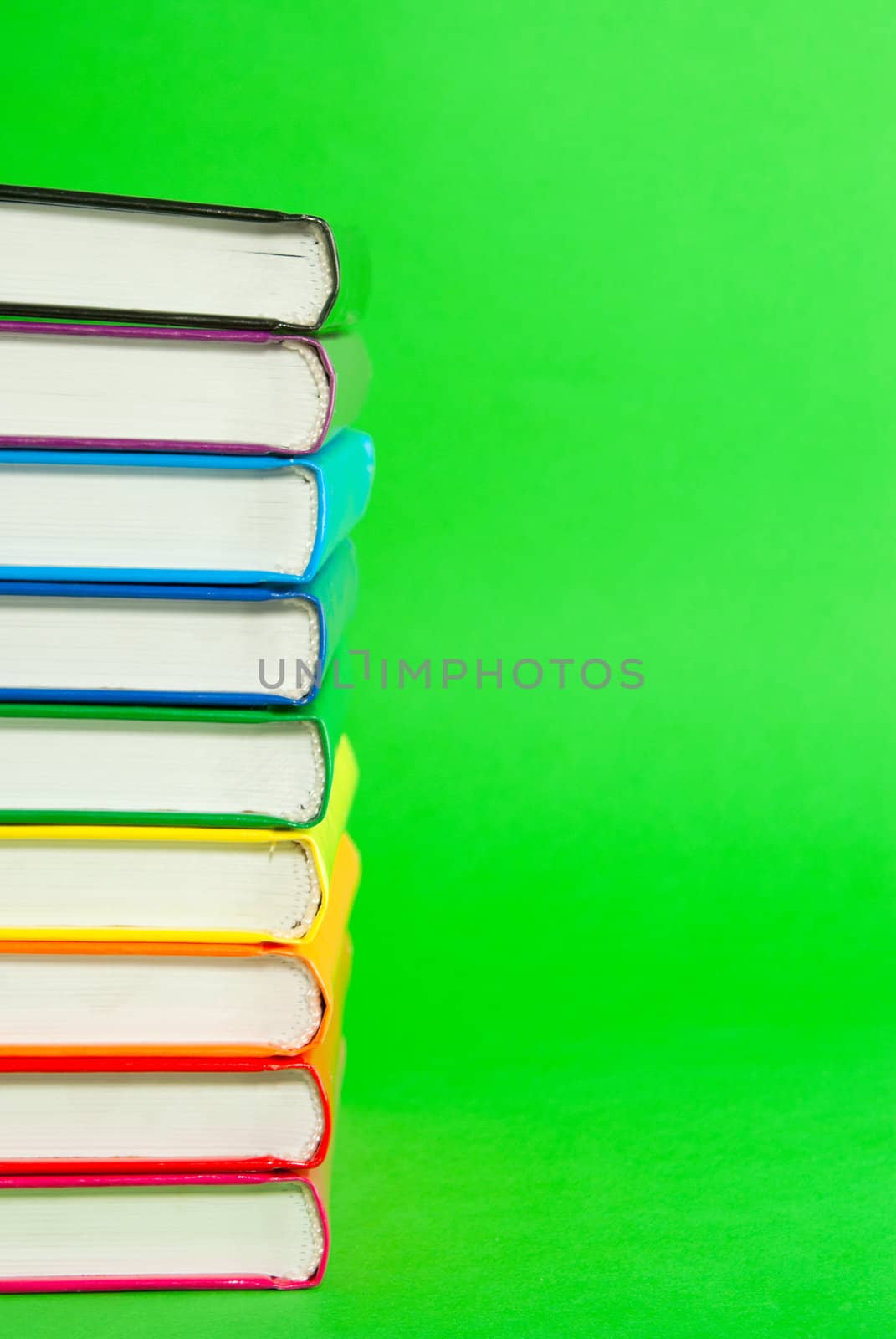 Stack of books' spines over green background