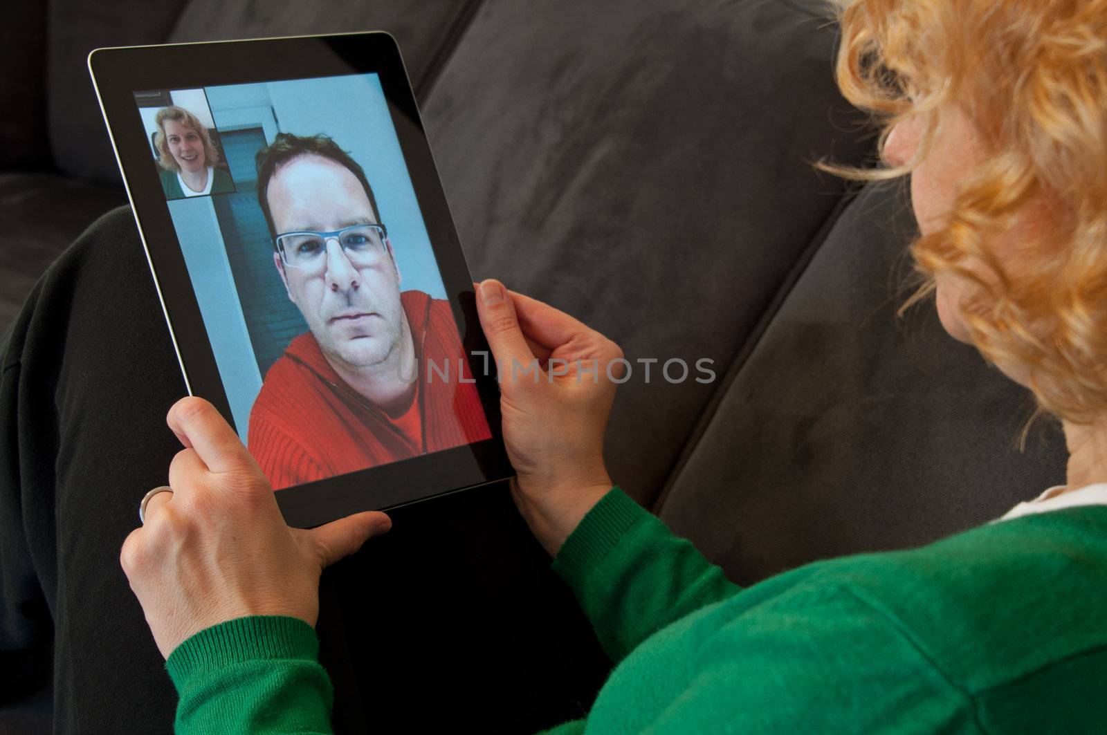 Middle-aged woman using video telephony on digital tablet pc