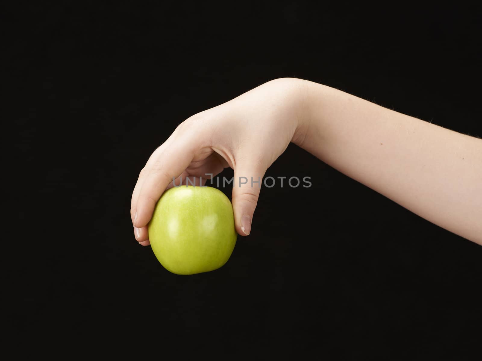 Childs hand with apple - on black background