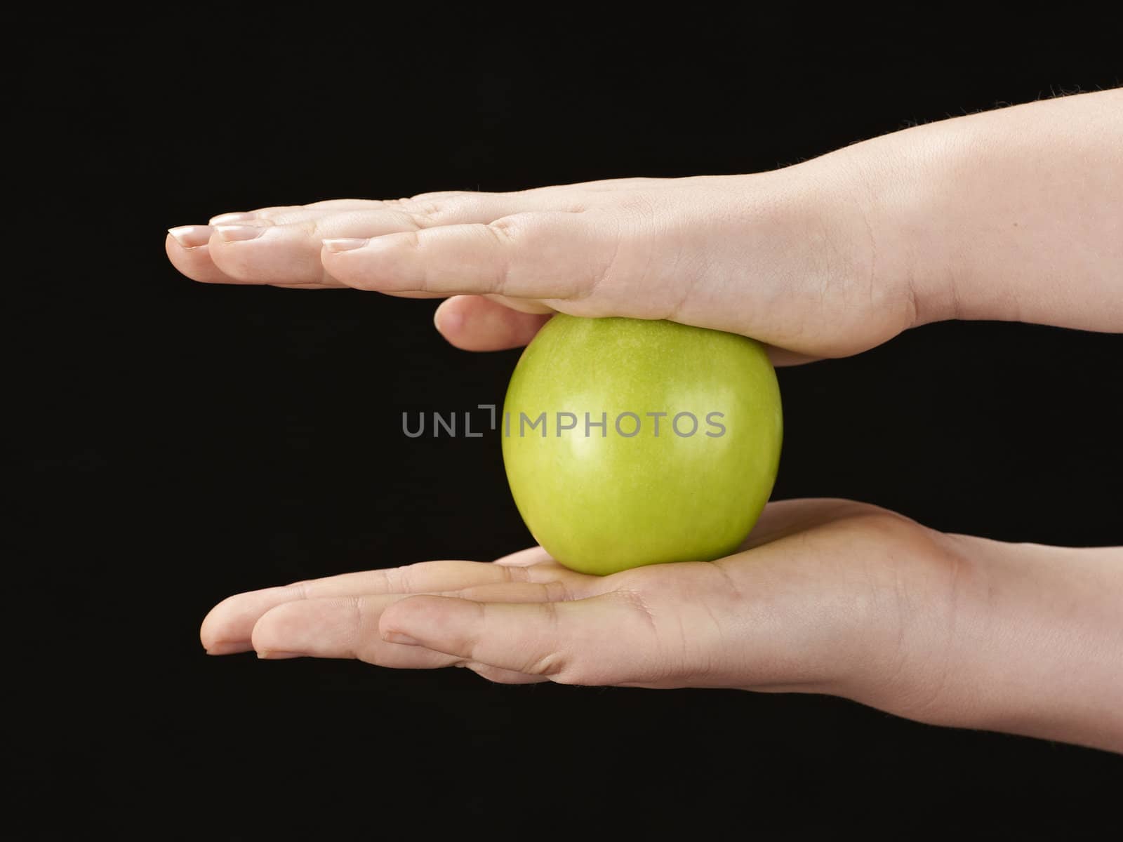 Childs hands with apple - on black background