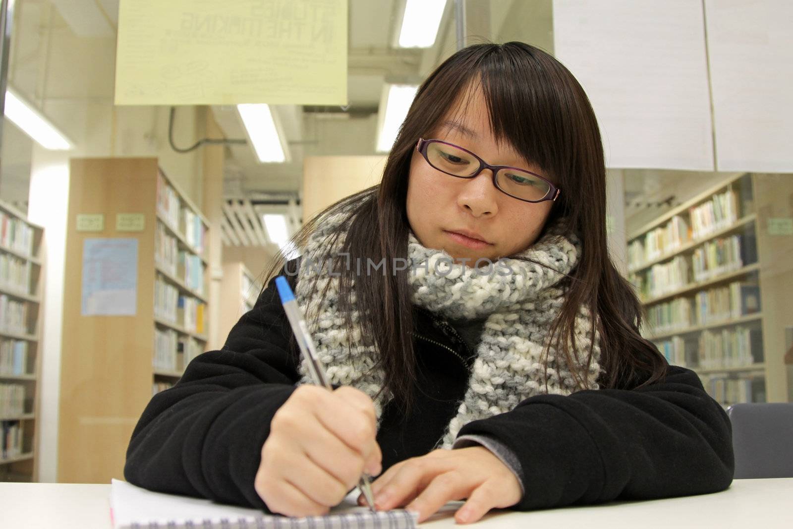 Asian woman studying hard in a university by kawing921