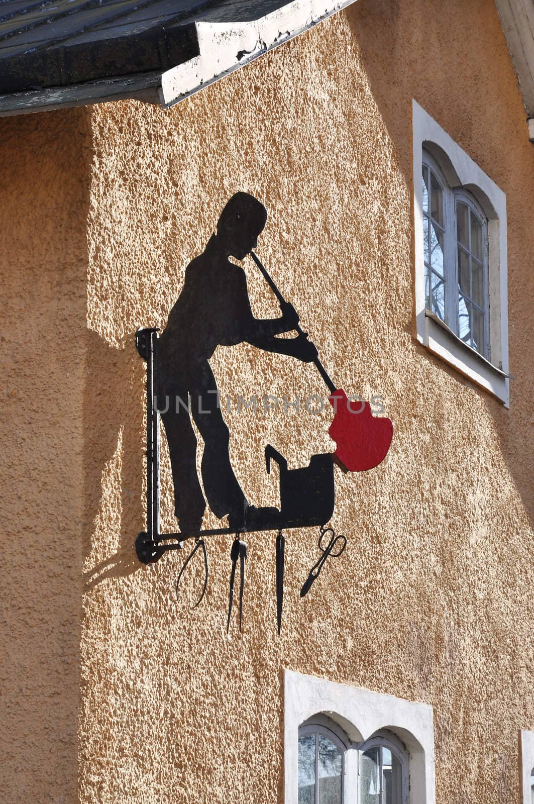 A glass blower as a sign on a building wall.