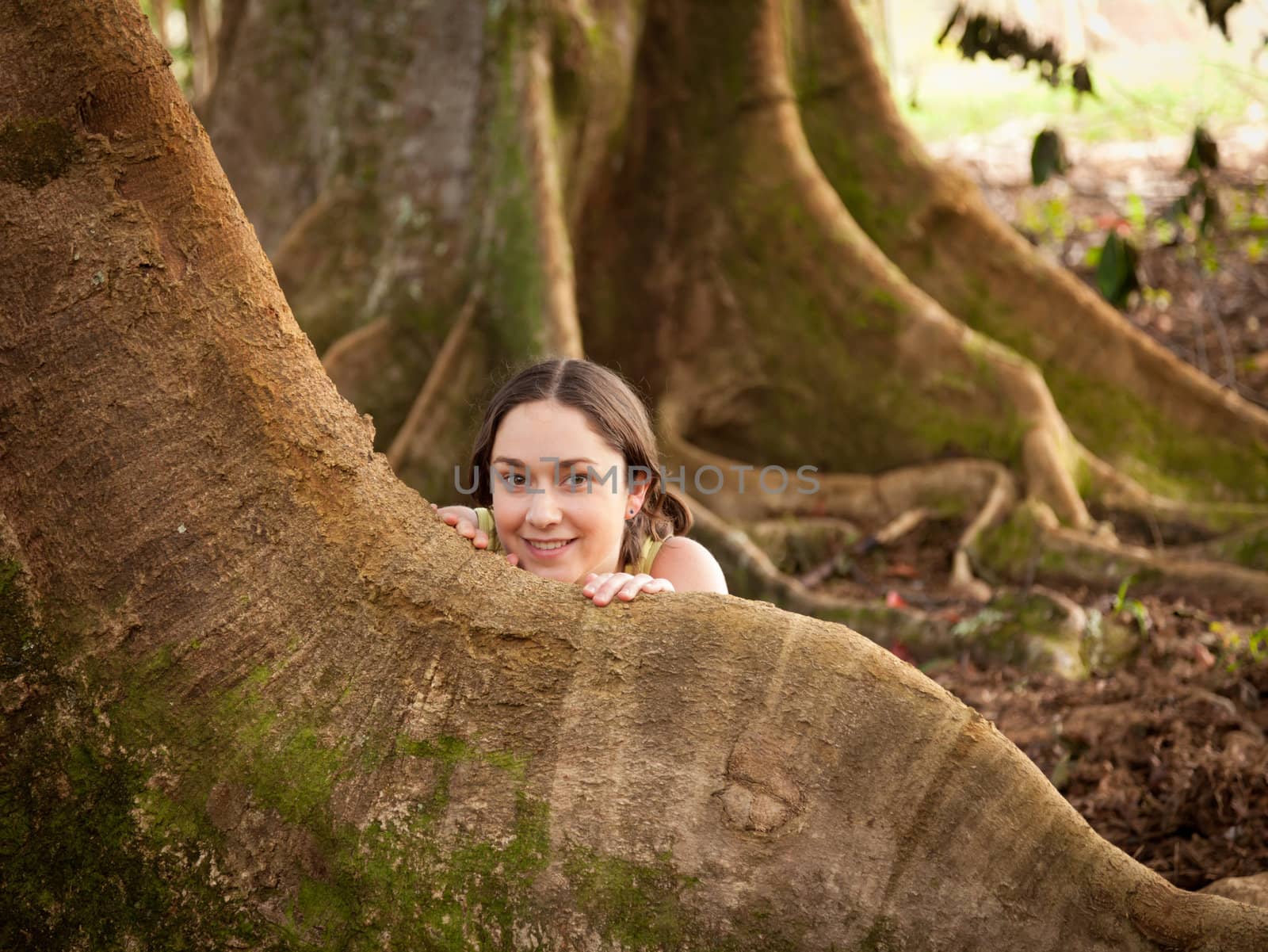 Girl looking from behind roots of the Moreton Bay fig tree