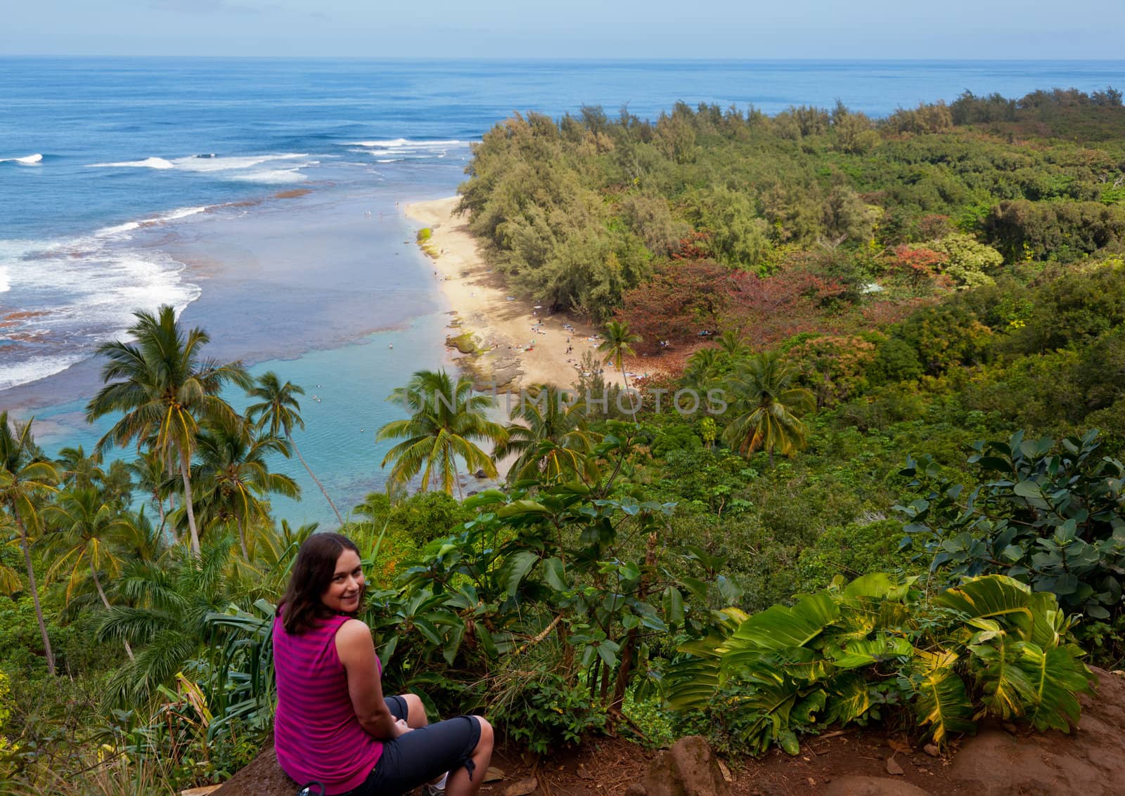 Female hiker overlooking Kee beach from Kalalau trail on Na Pali coast of Kauai