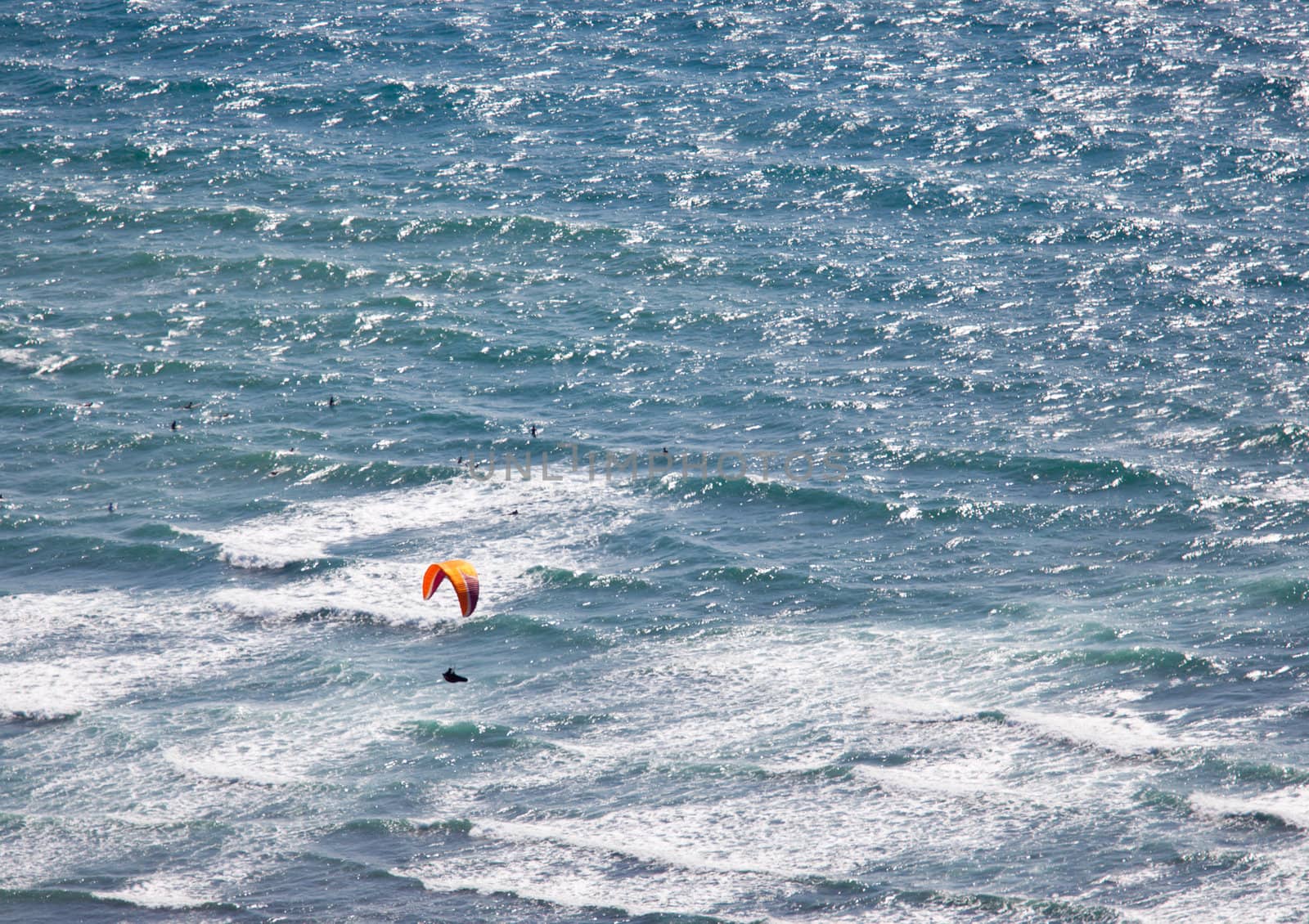 Overhead view of hang glider over rough ocean off Hawaii