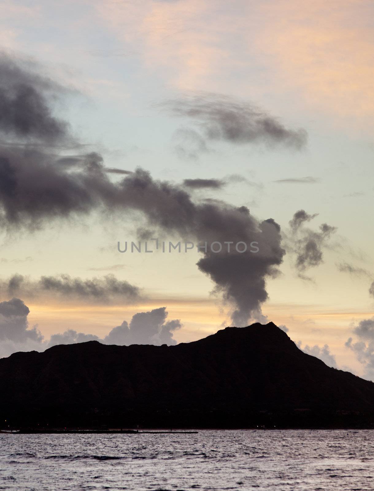 Clouds appear to be smoke from volcano of Diamond Head at sunrise in Hawaii