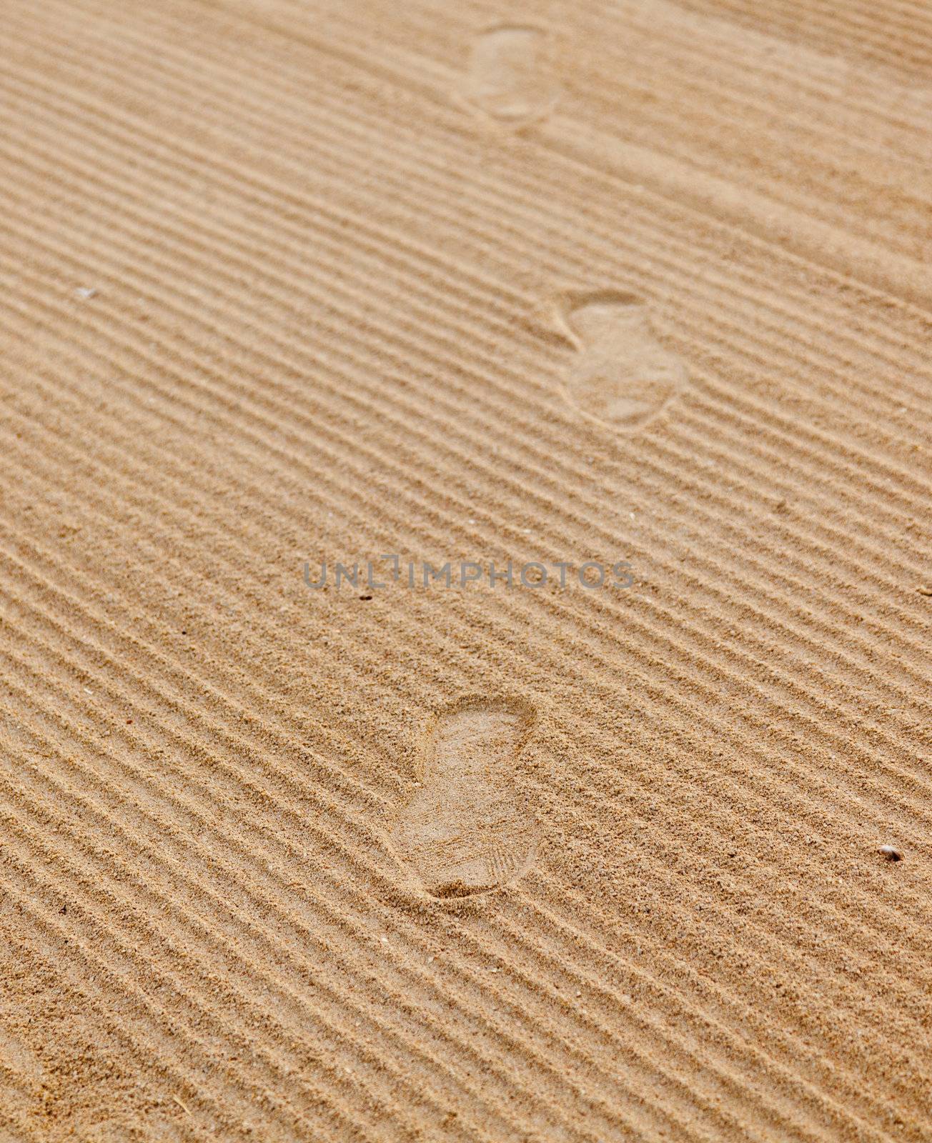 Shoe footprints in rippled sand on beach