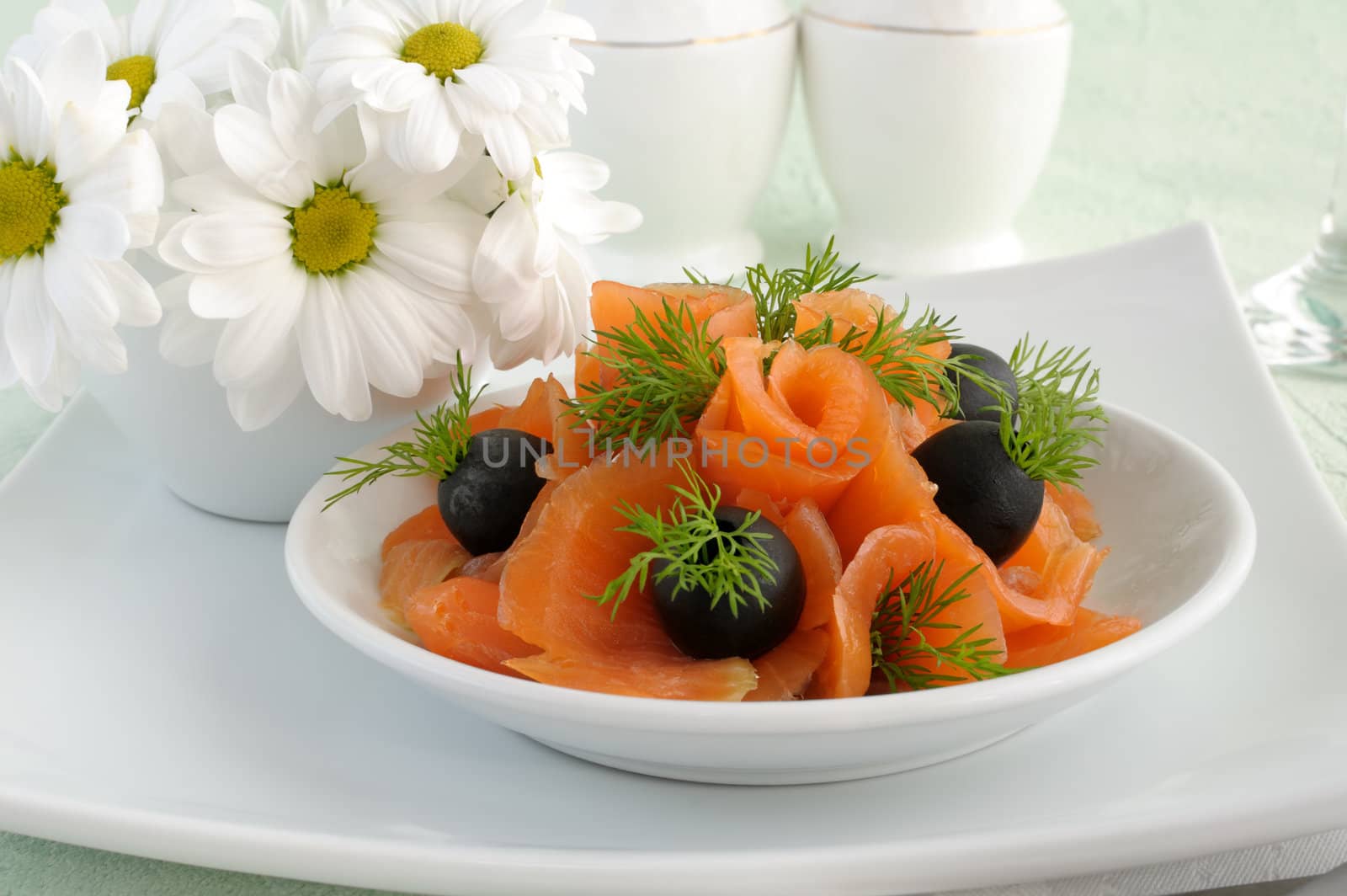Appetizer of salmon with olives and dill closeup