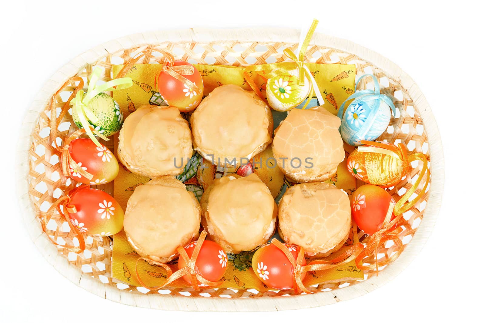 easter eggs and homemade sweet cakes in basket on white