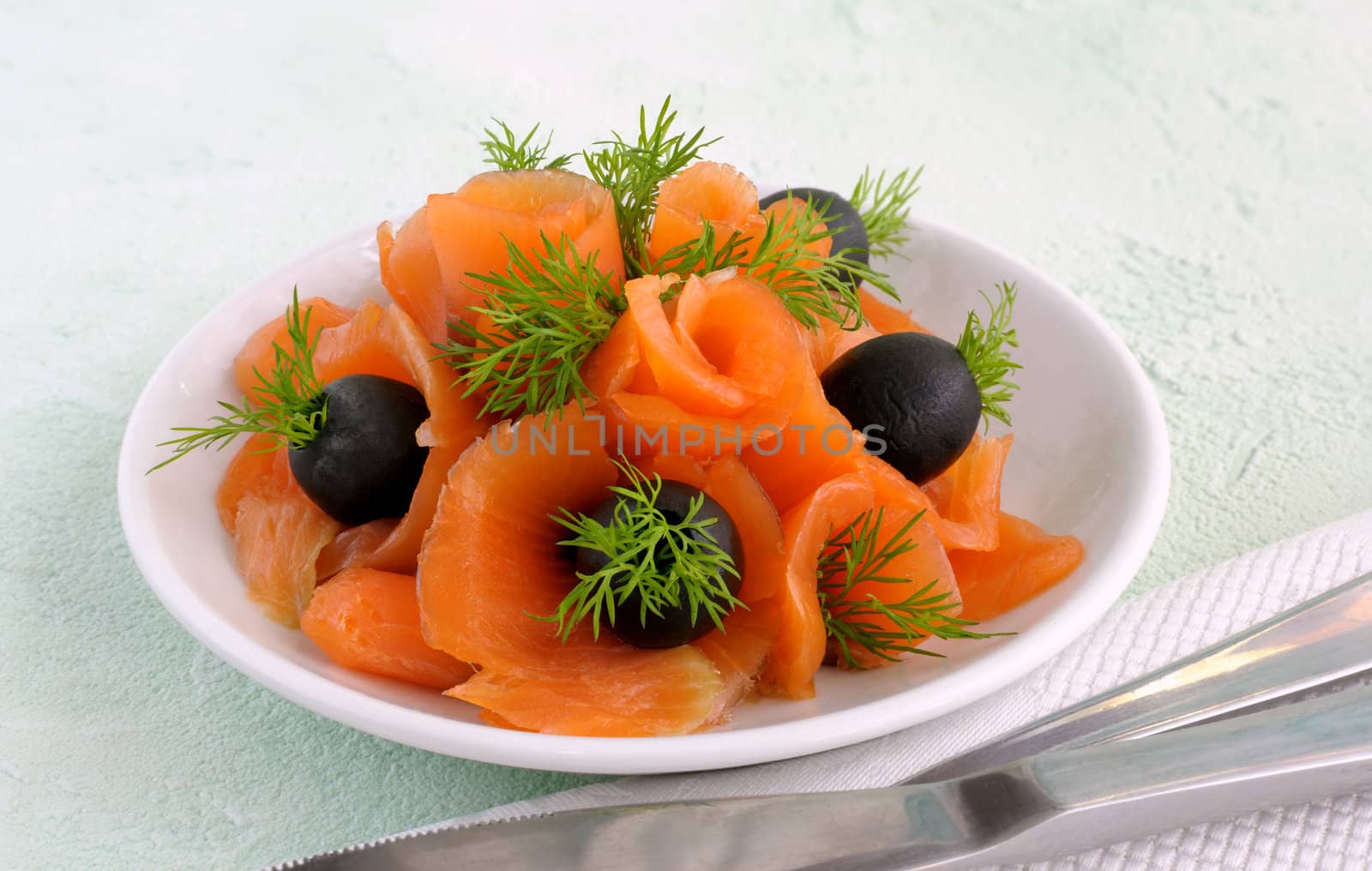 Appetizer of salmon with olives and dill closeup